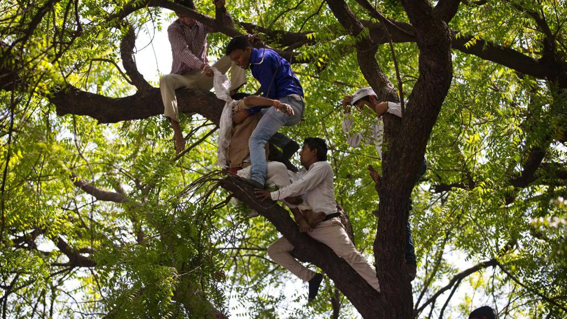 Volunteers of the Aam Admi Party try to rescue Gajendra Singh, who hanged himself during a farmer’s rally in New Delhi, India, Wednesday, April 22, 2015. According to a note he left behind and which police recovered, Singh killed himself after his father, left with nothing after rainstorms destroyed their crops, forced him from the family home. It was the latest in a wave of suicides that has left at least 40 farmers dead in recent weeks. (AP Photo/Saurabh Das)