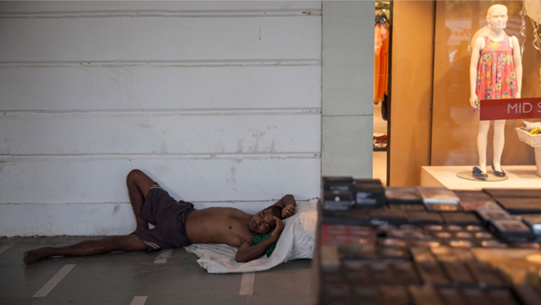 May 27, 2015: An Indian homeless man sleeps on a pavement in a market area on a hot summer day in New Delhi. In southern India, hundreds of people have died since the middle of April as soaring summer temperatures scorch the country, officials said Tuesday. (AP Photo/Tsering Topgyal)