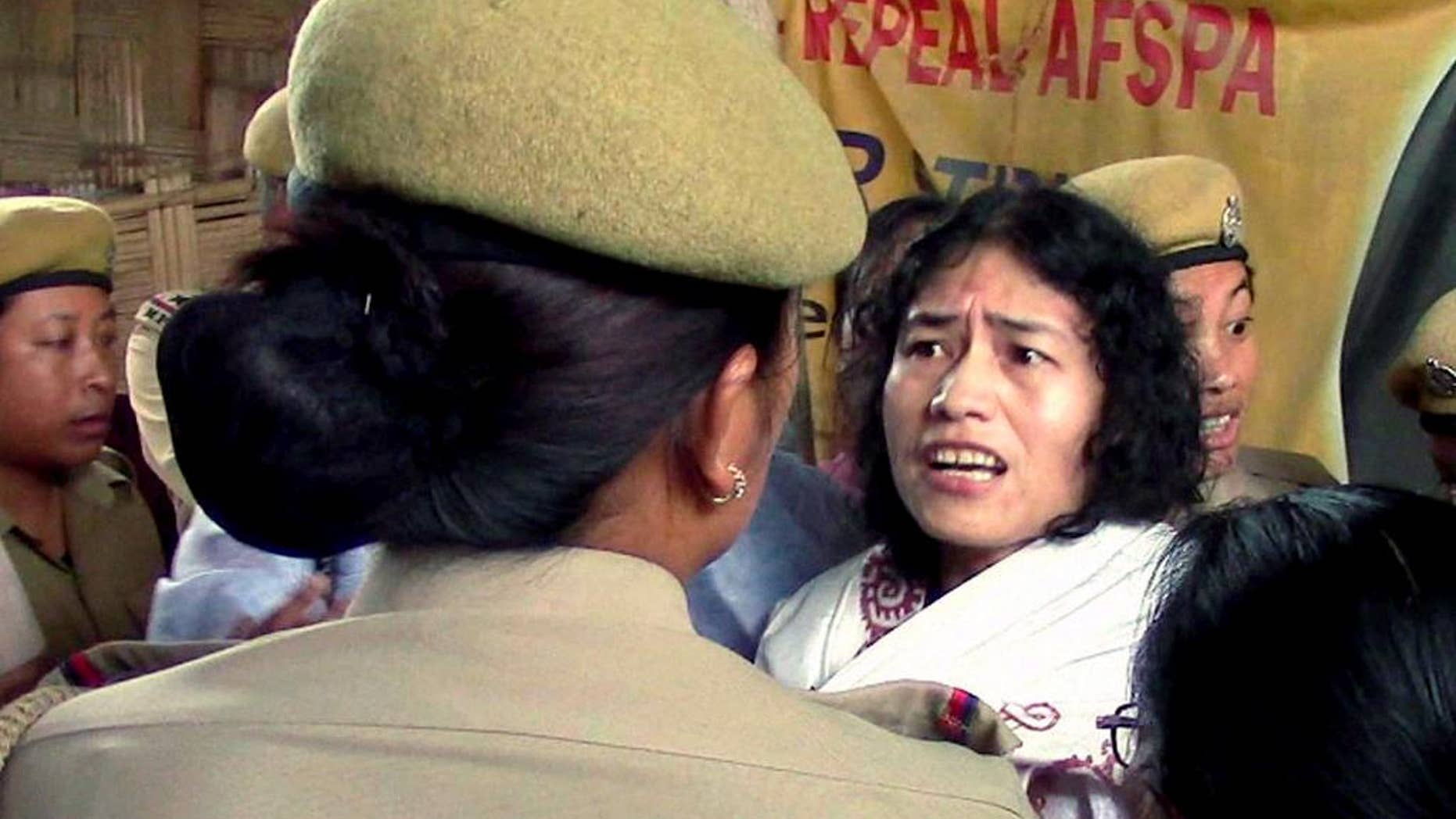 In this Friday, Aug. 22, 2014 photo, Irom Sharmila is detained by policewomen in Imphal, in the northeastern Indian state of Manipur. The frail Indian activist who has been on a hunger strike for nearly 14 years to protest alleged military brutality scuffled with police Friday as they took her back to the same government hospital where she had been force-fed. Sharmila, 42, vowed to continue the hunger strike that landed her in prison for the past 14 years. She walked free on Wednesday after a court threw out the charges of attempted suicide against her. Attempted suicide is a crime in India. (AP Photo/Press Trust of India) INDIA OUT