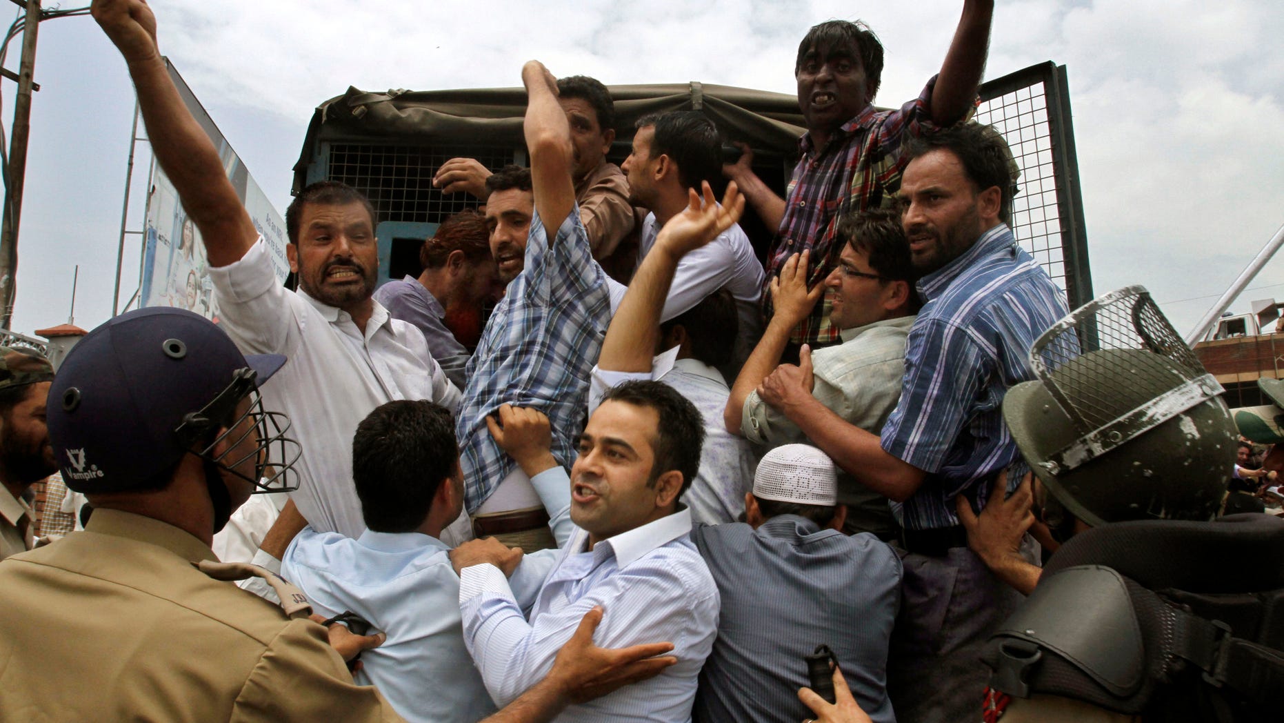 Indian policemen detain Jammu Kashmir state government employees as they shout slogans during a protest in Srinagar, India, Monday, July 18, 2011. The employees demanded payment of arrears in salaries, raising of retirement age and other demands.