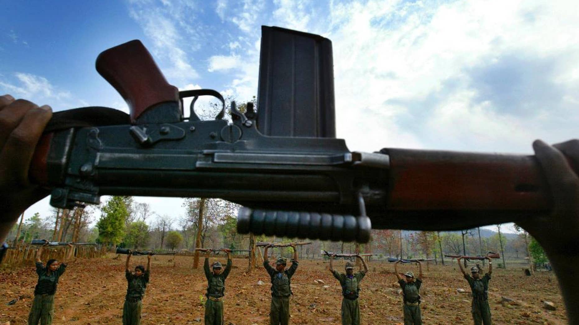 FILE - In this April 13, 2007 file photo, Maoist rebels or Naxalites, officially the Communist Party of India (Maoist) that takes its name from the Naxalbari, a village outside Kolkata where the revolt began in 1967, raise their arms during an exercise at a temporary base in the Abujh Marh forests, in the central Indian state of Chhattisgarh. Maoist rebels killed one villager and released around 250 others they had held for a day to stop the construction of a bridge in central India, police said Sunday, May 10, 2015.(AP Photo/Mustafa Quraishi, File)