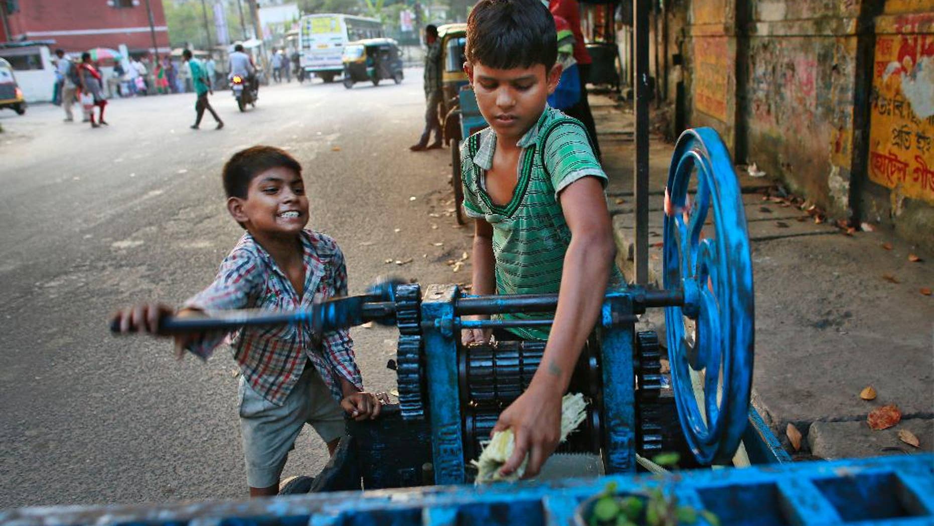 Ravi, 8, left, and Guddu, 12, extract sugarcane juice, in Gauhati, India, Friday, Oct. 10, 2014. Malala Yousafzai of Pakistan and Kailash Satyarthi of India won the Nobel Peace Prize on Friday, Oct. 10, 2014, for risking their lives to fight for children’s rights. (AP Photo/Anupam Nath)