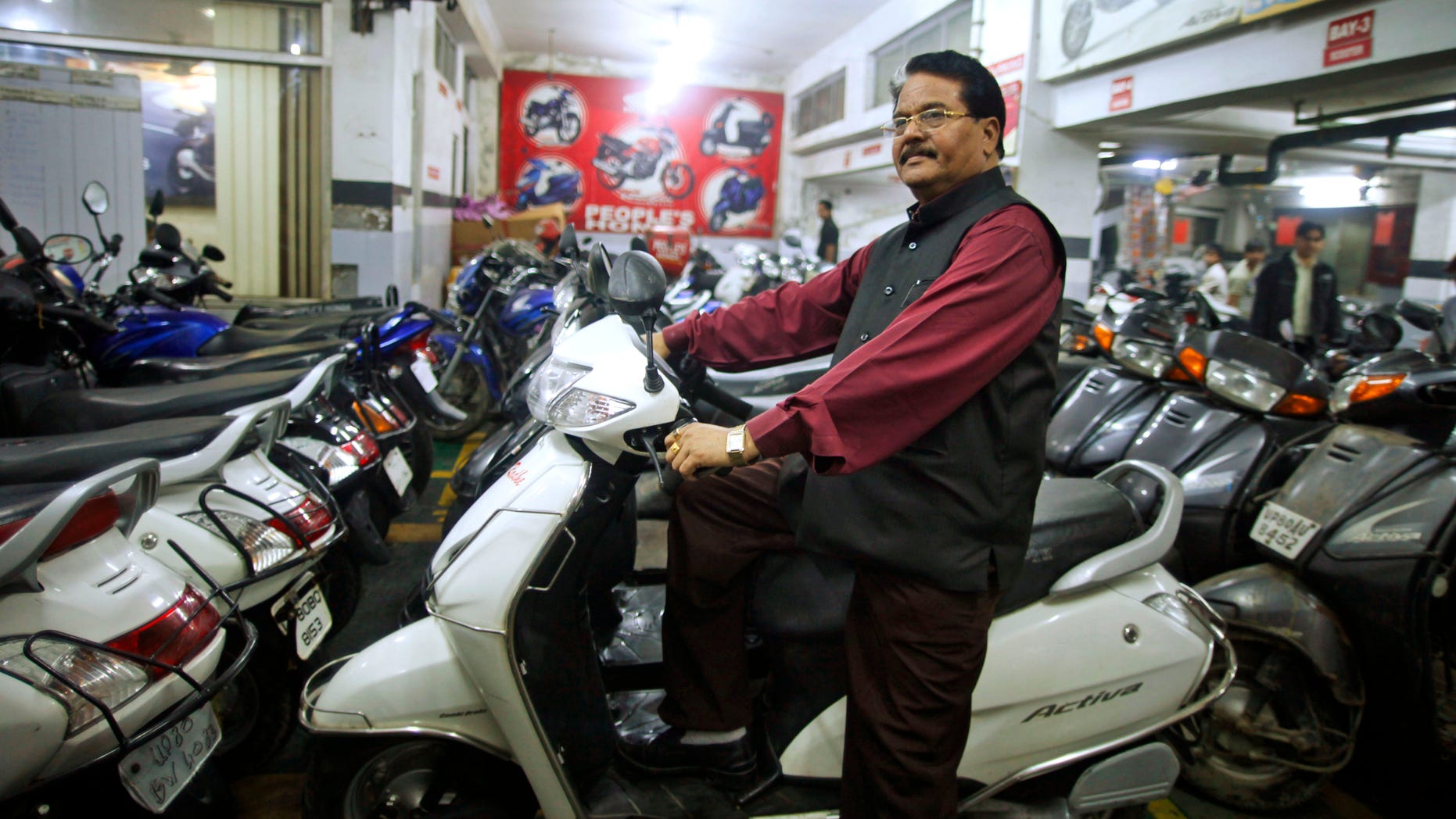 Hari Kishan Pippal, 60, a member of India's outcast community once known as untouchables, sits on a scooter inside his Honda dealership showroom in Agra, India. Raised in poverty, he only made it through high school before his father became ill, and he had to go to work pulling a rickshaw to support the family.
