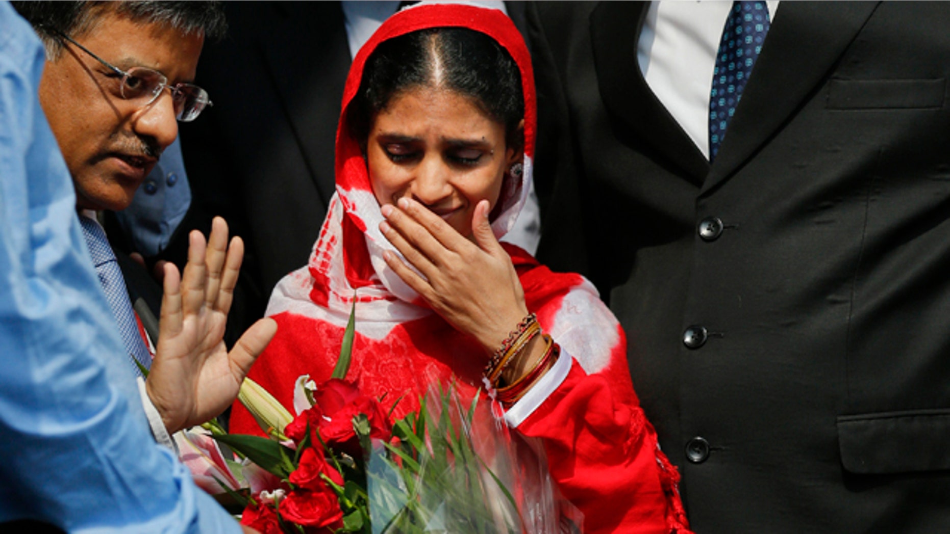 Oct. 26, 2015: Geeta, 23, center, a deaf and mute Indian woman who accidentally strayed into Pakistan as a child 12 years ago, arrives at the airport in New Delhi. (AP Photo /Tsering Topgyal)