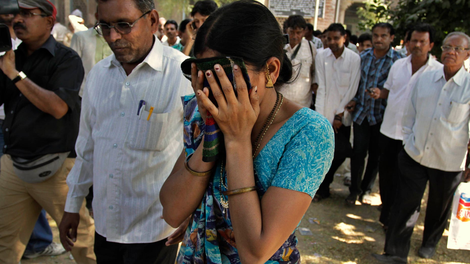 Nov. 9, 2011: An unidentified relative of one of the convicted Hindus breaks down upon hearing the verdict at the district court in Mehsana, about 25 miles north of Ahmadabad, India.