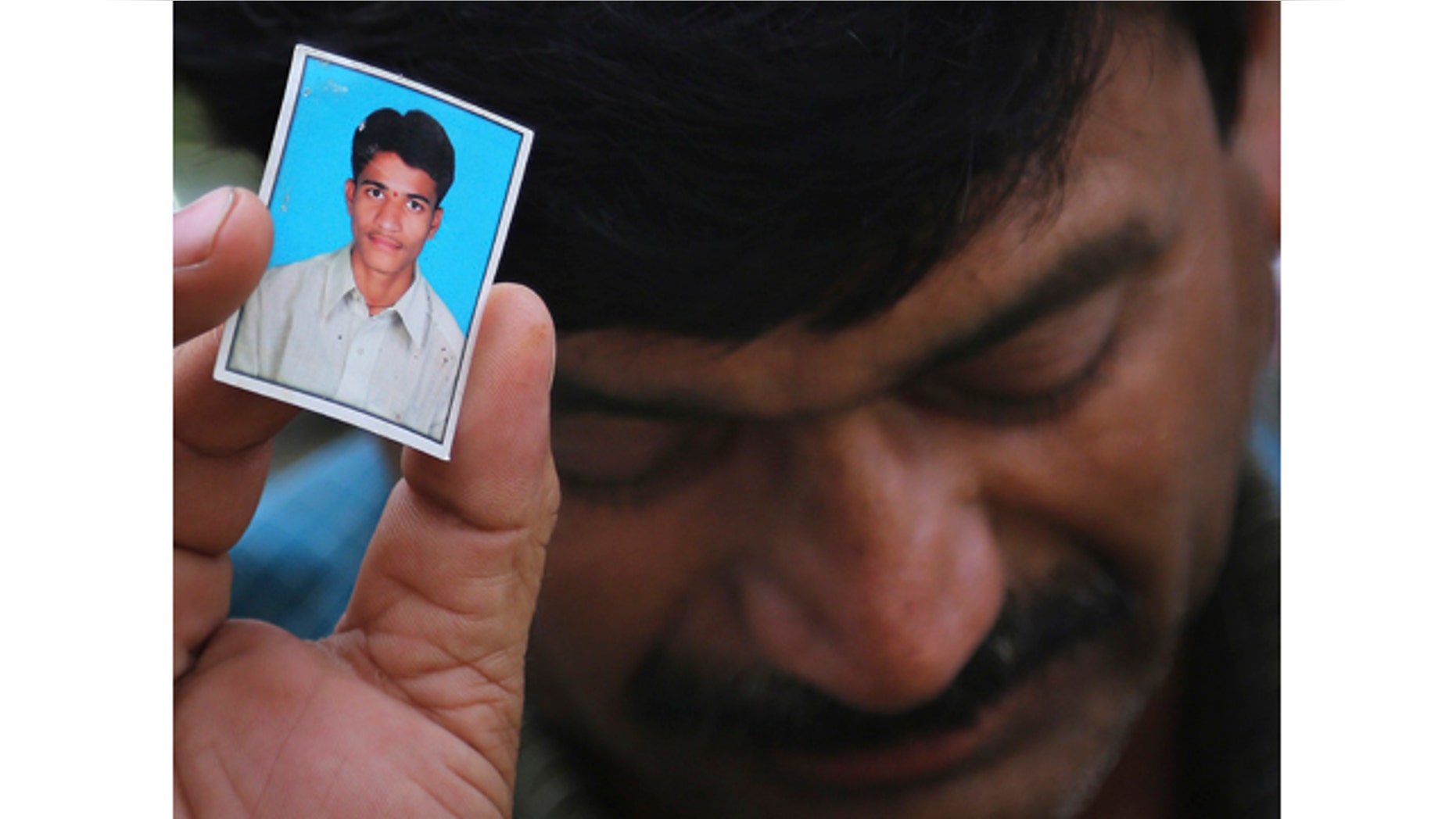 June 9, 2014: Bonath Shekar Naik shows a portrait of his son Rambabu, one of the 24 students feared dead during a field trip near the mountain resort town of Manali, at the college premises of VNR Vignana Jyothi Institute of Engineering and Technology, on the outskirts of Hyderabad, India. (AP Photo/ Mahesh Kumar A.)