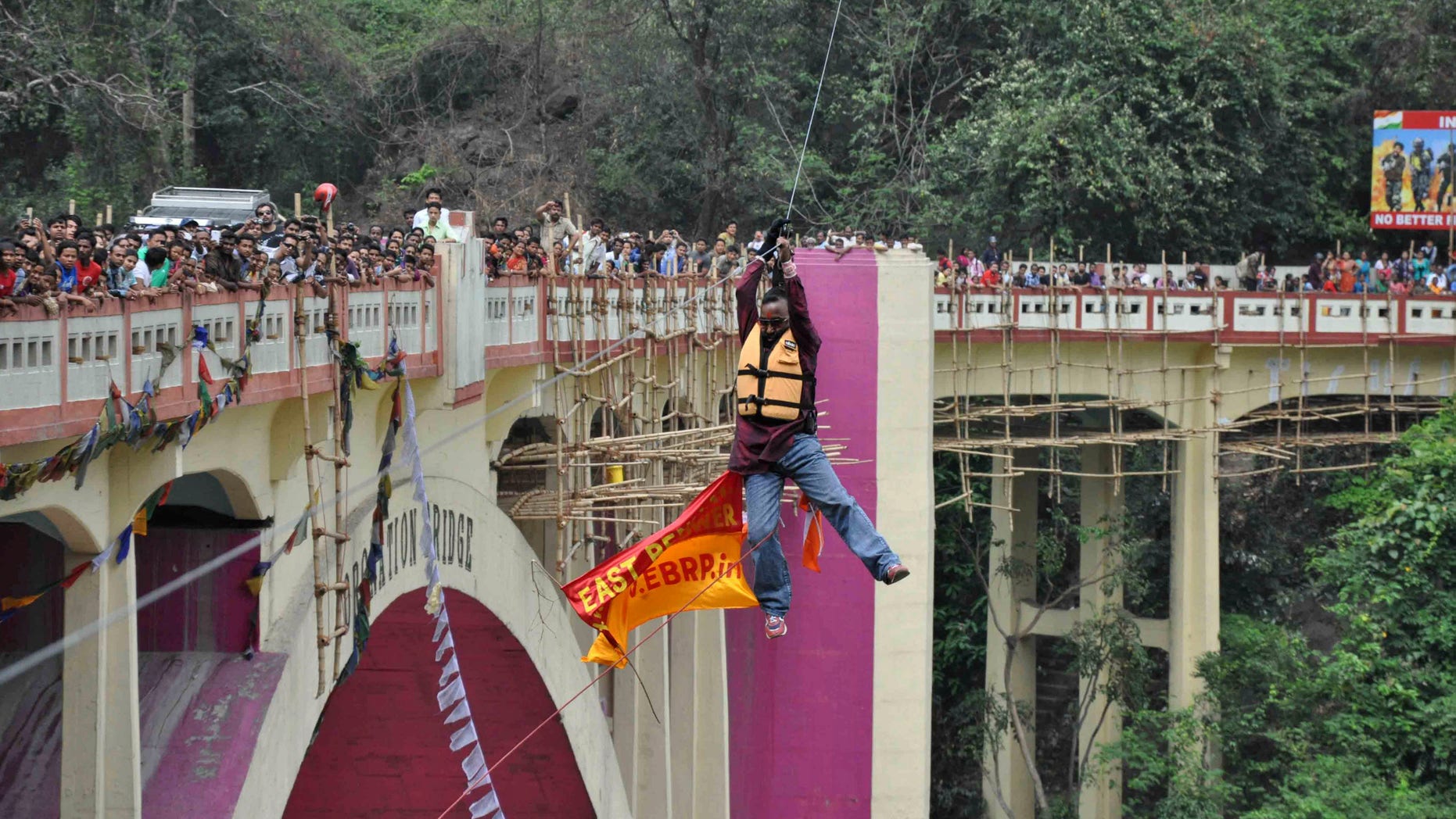 April 28, 2013 - People watch as Indian Sailendra Nath Roy attempts to cross Teesta river suspended from a zip wire attached to his ponytail moments before his death in Siliguri, West Bengal state, India.