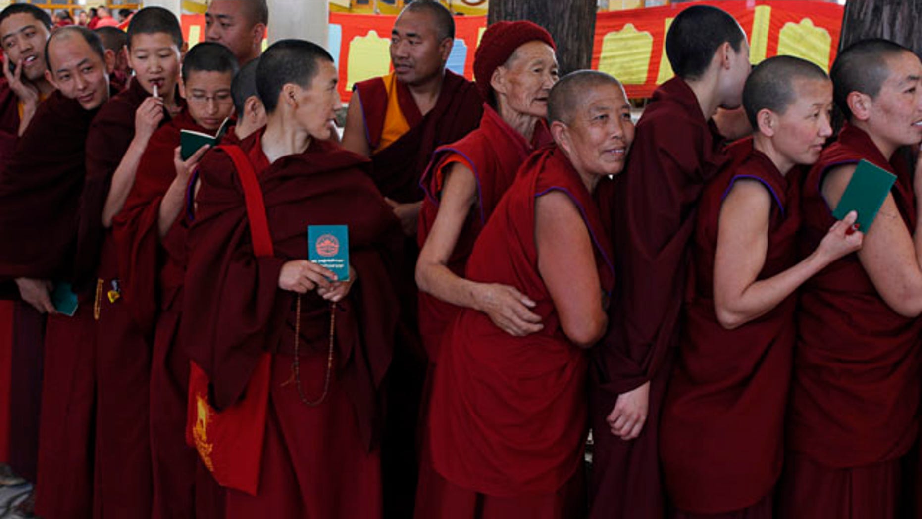 March 20, 2011: Exile Tibetan Buddhist monks and nuns line up with their green books to cast their votes during the final round of voting to choose the next exile Tibetan prime minister and the members of the Tibetan parliament-in-exile in Dharmsala, India.