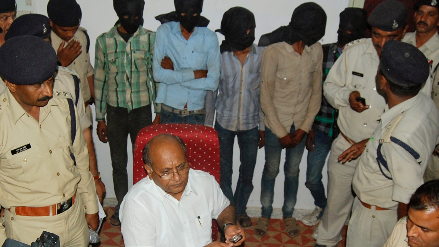 March 17, 2013 - 5 men, faces covered, who are among the 6 accused of raping a Swiss tourist cycling with her husband in central India, stand at a police control room after they were detained, in Datia, India.