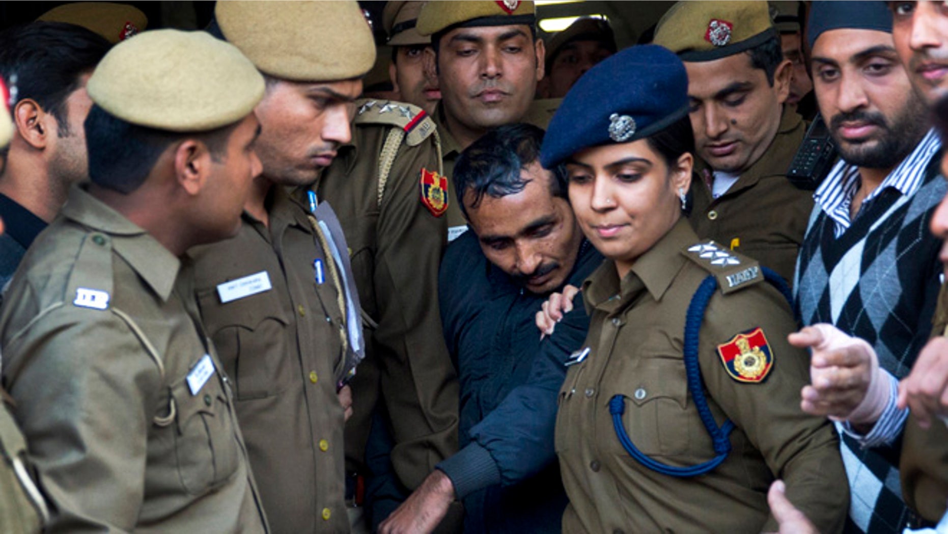 Dec. 8, 2014: Shiv Kumar Yadav, center, a driver from the international taxi-booking service Uber, is surrounded by police as he is brought out after being produced in a court in New Delhi, India.