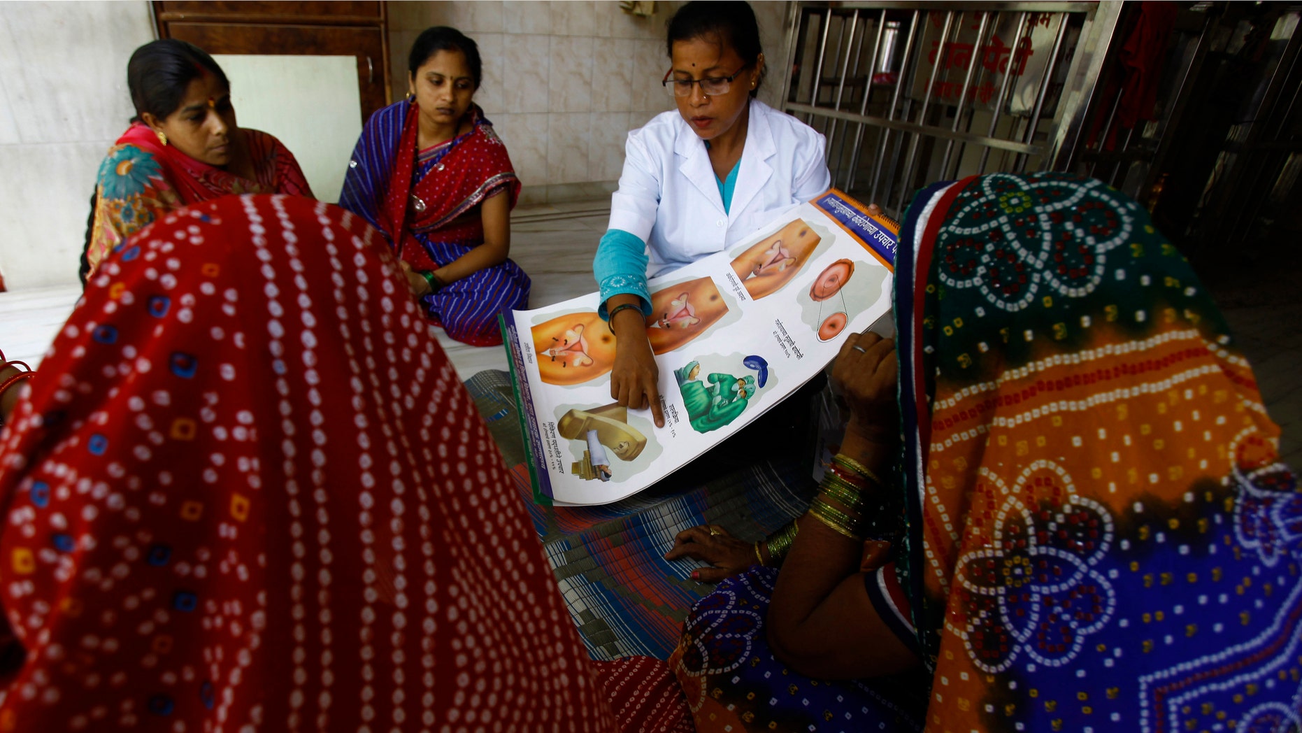 In this Tuesday, May 21, 2013 photo, Anjali S, a health work from Tata Memorial Hospital, briefs a group of women about cervical cancer during one of her regular visit to a slum in Mumbai, India. (AP Photo/Rafiq Maqbool)