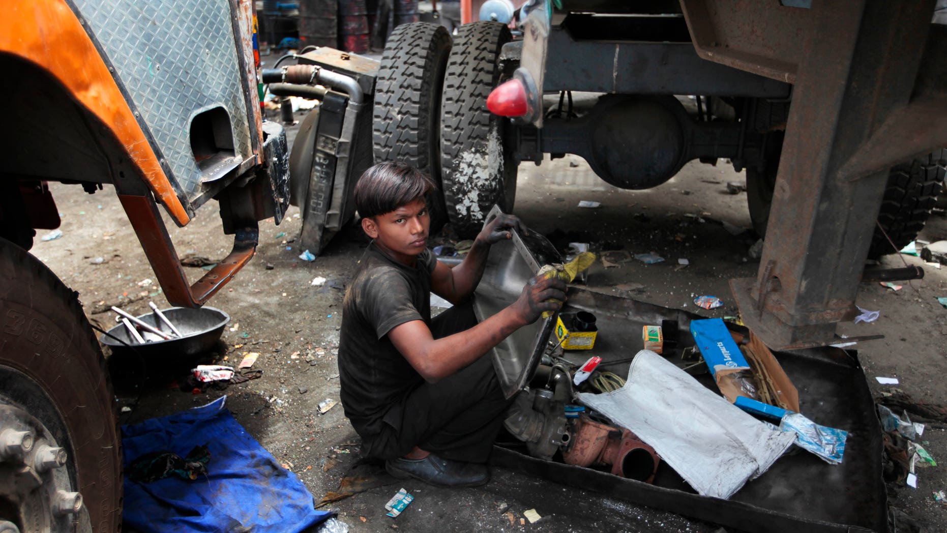 June 12, 2012: A young boy cleans parts of a truck on World Day Against Child Labor in New Delhi, India.