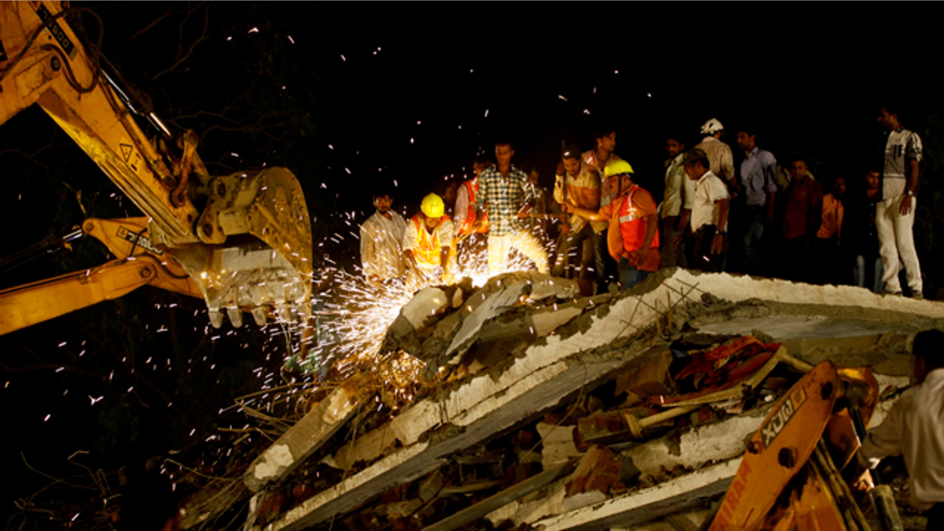 April 4, 2013: Rescue workers look for trapped people after a residential building collapsed in Thane, Mumbai, India.