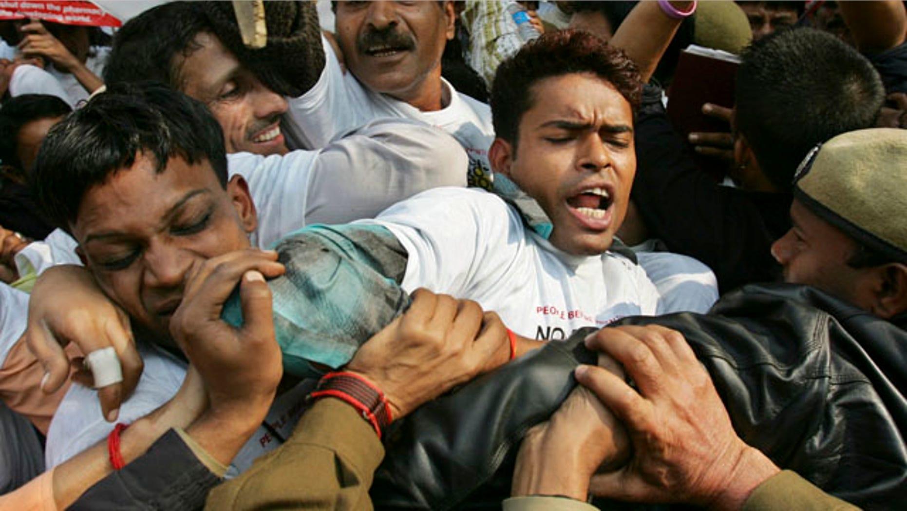 FILE: Indian police officers block demonstrators protesting against drug manufacturer Novartis' case against Indian government on drug patents in New Delhi, India.