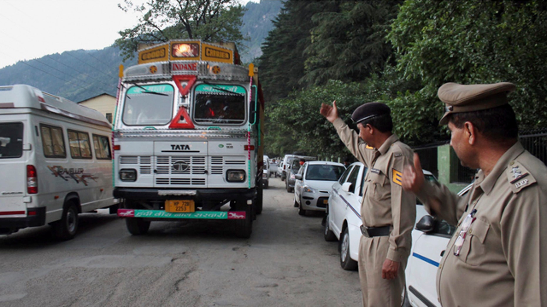 June 4, 2013: Indian policemen keep a check on vehicles after an American woman was gang-raped Tuesday in the northern Indian resort town of Manali, India.