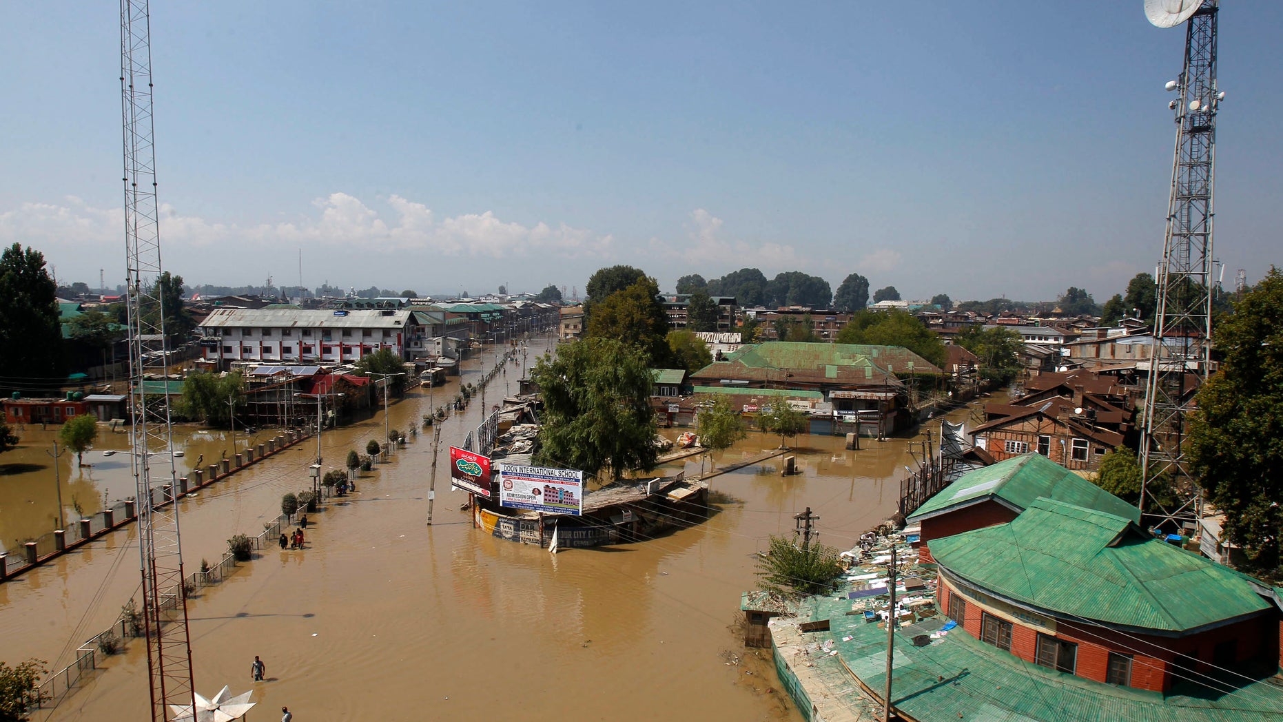 A view shows people wading through a flooded street in Srinagar September 15, 2014. Indian emergency workers on Monday battled to prevent waterborne diseases like cholera from spreading as fetid water swilled around the Kashmir valley more than a week after the worst flooding in more than a century. REUTERS/Danish Ismail