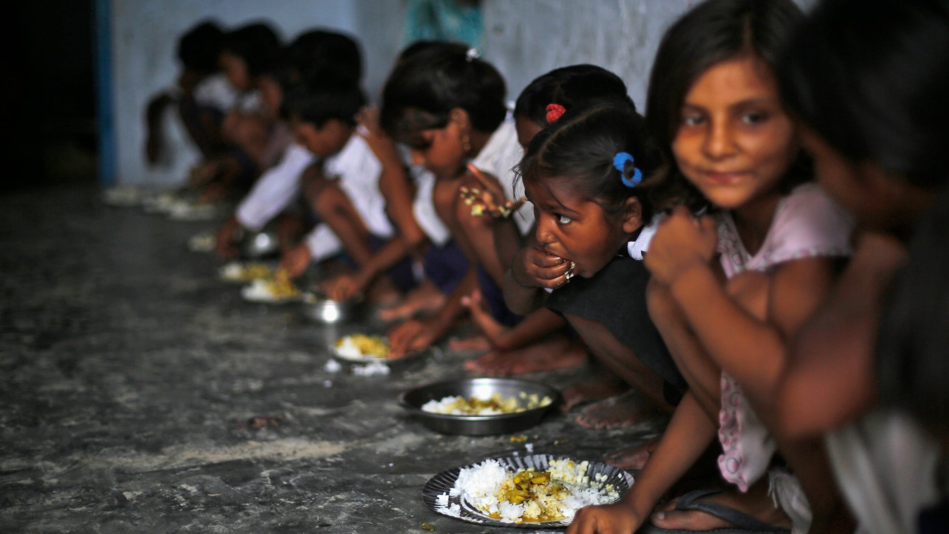 School children eat their free mid-day meal, distributed by a government-run primary school in the eastern Indian state of Bihar July 19, 2013.