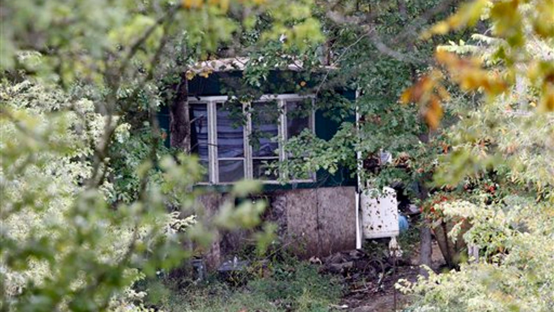 Sept. 26: Trees and brush surround the mobile home of Roy Napier where four people were found dead in rural Franklin County near Laurel, Ind. A fifth person was found dead across the street.