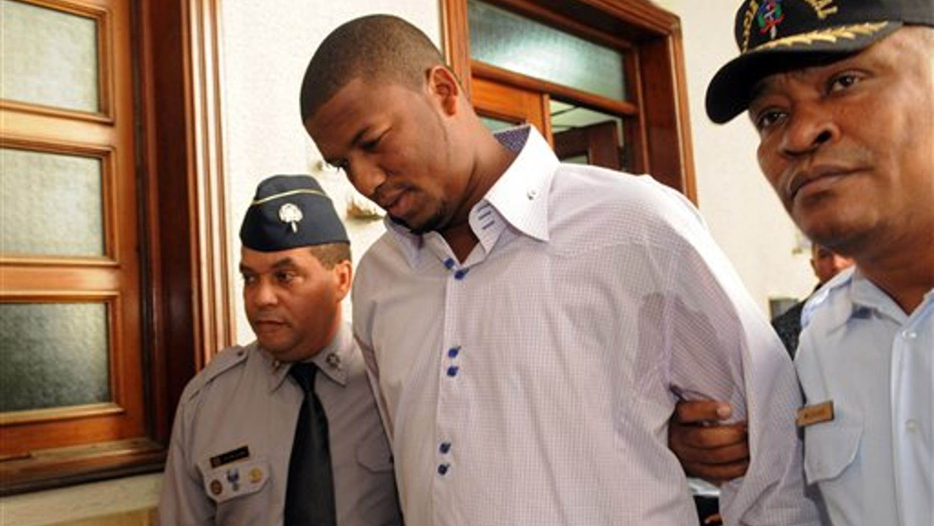 Jan. 20, 2012: Cleveland Indians pitcher Fausto Carmona, whose real name is Roberto Hernandez Heredia, is escorted by police out of court in Santo Domingo, Dominican Republic.