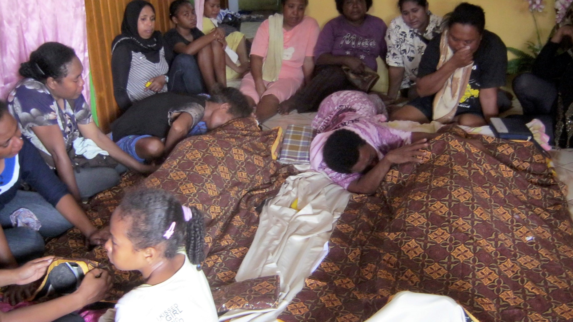 July 15, 2013 - Relatives mourn around the bodies of Yanus Manibui and his wife Anance Woyaa who were victims in a stampede at Kota Lama Sport Stadium after spectators rioted to protest a local boxer's loss in Nabire, Papua province, Indonesia. More than a dozen people were killed in the stadium stampede. The victims, mostly women, were trampled to death as about 1,500 spectators scrambled out of the stadium to escape the riot.