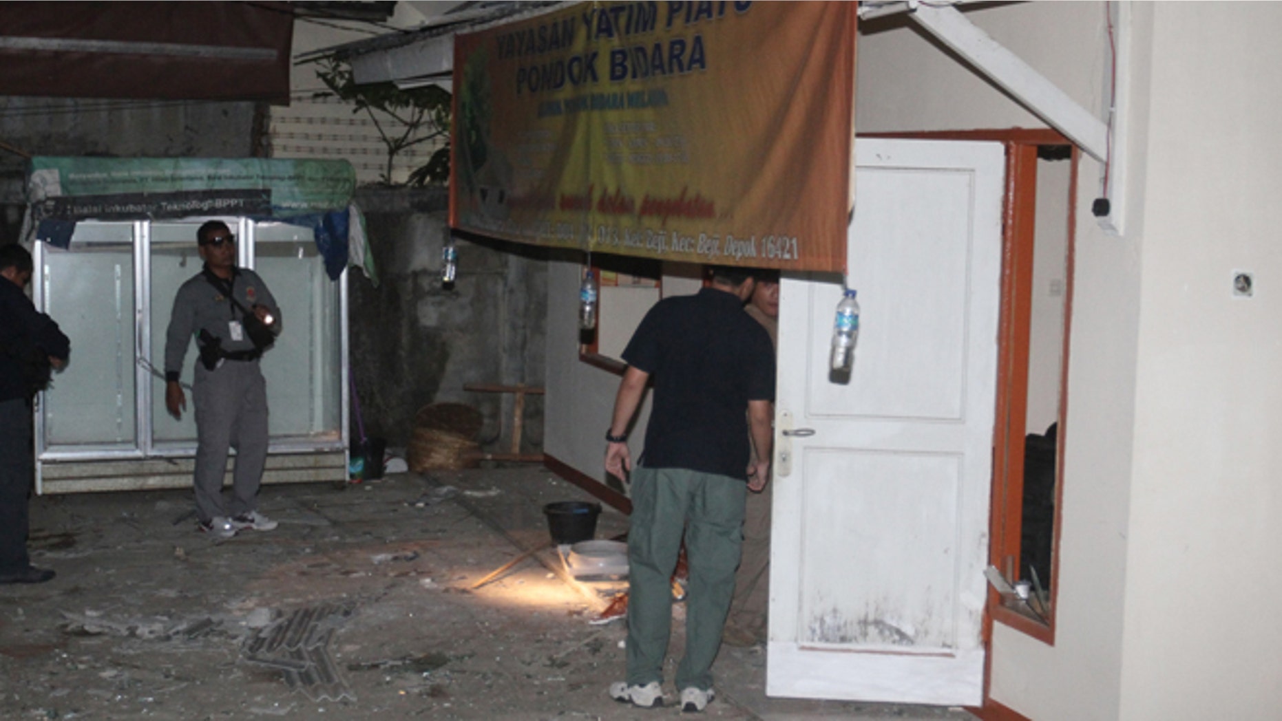 Sept. 8, 2012: Plain-clothed police officers examine a house where an explosion went off in Depok, West Java, Indonesia.