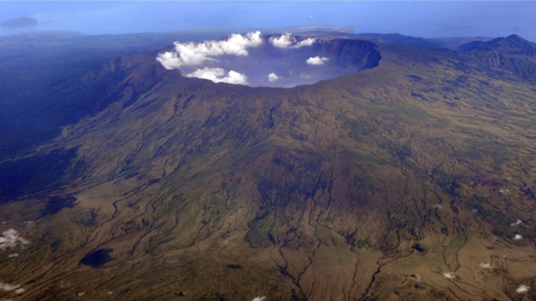 Oct. 19, 2010" Mount Tambora's 10 kilometer wide and 1 kilometer deep volcanic crater, created by the April 1815 eruption, is shown. Bold farmers routinely ignore orders to evacuate the slopes of live volcanos in Indonesia, but those on Tambora took no chances when history's deadliest mountain rumbled ominously this month, Sept., 2011.