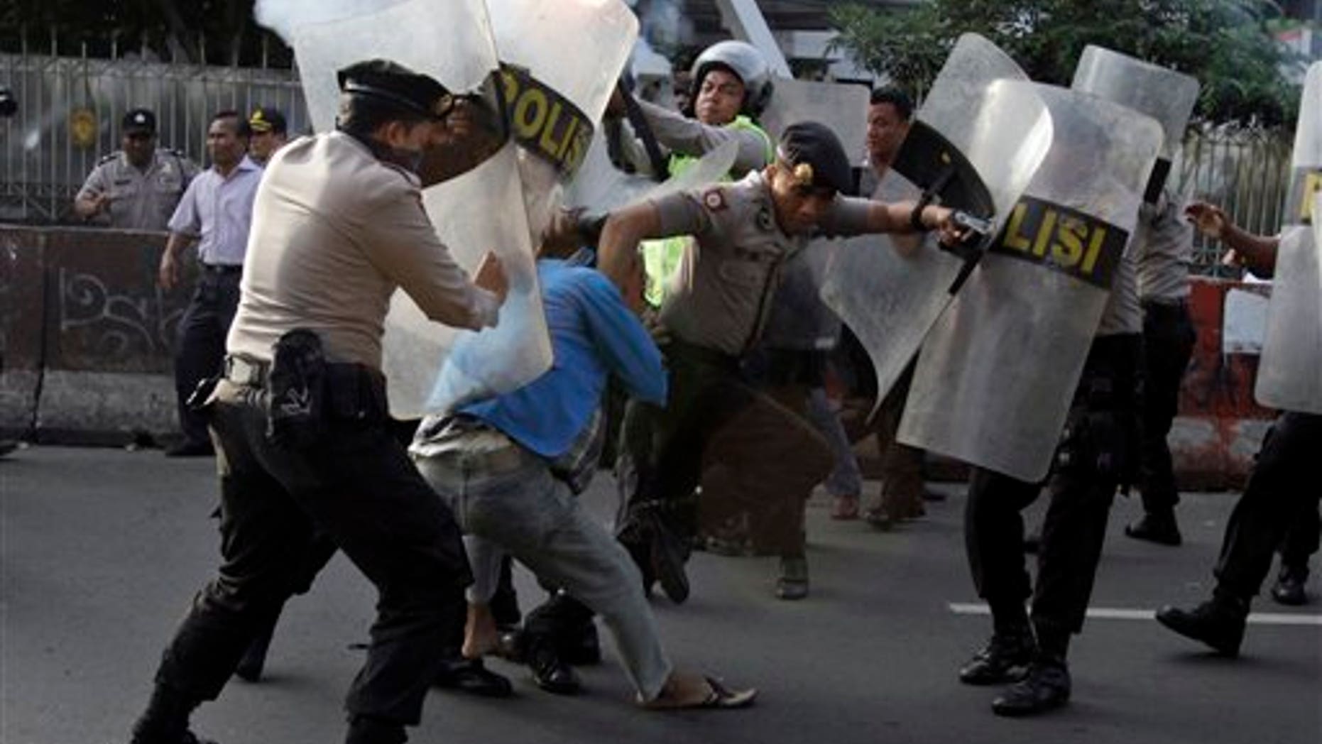 March 14: Indonesian police officers try to catch students during a protest against price hikes on fuel, in Jakarta, Indonesia.