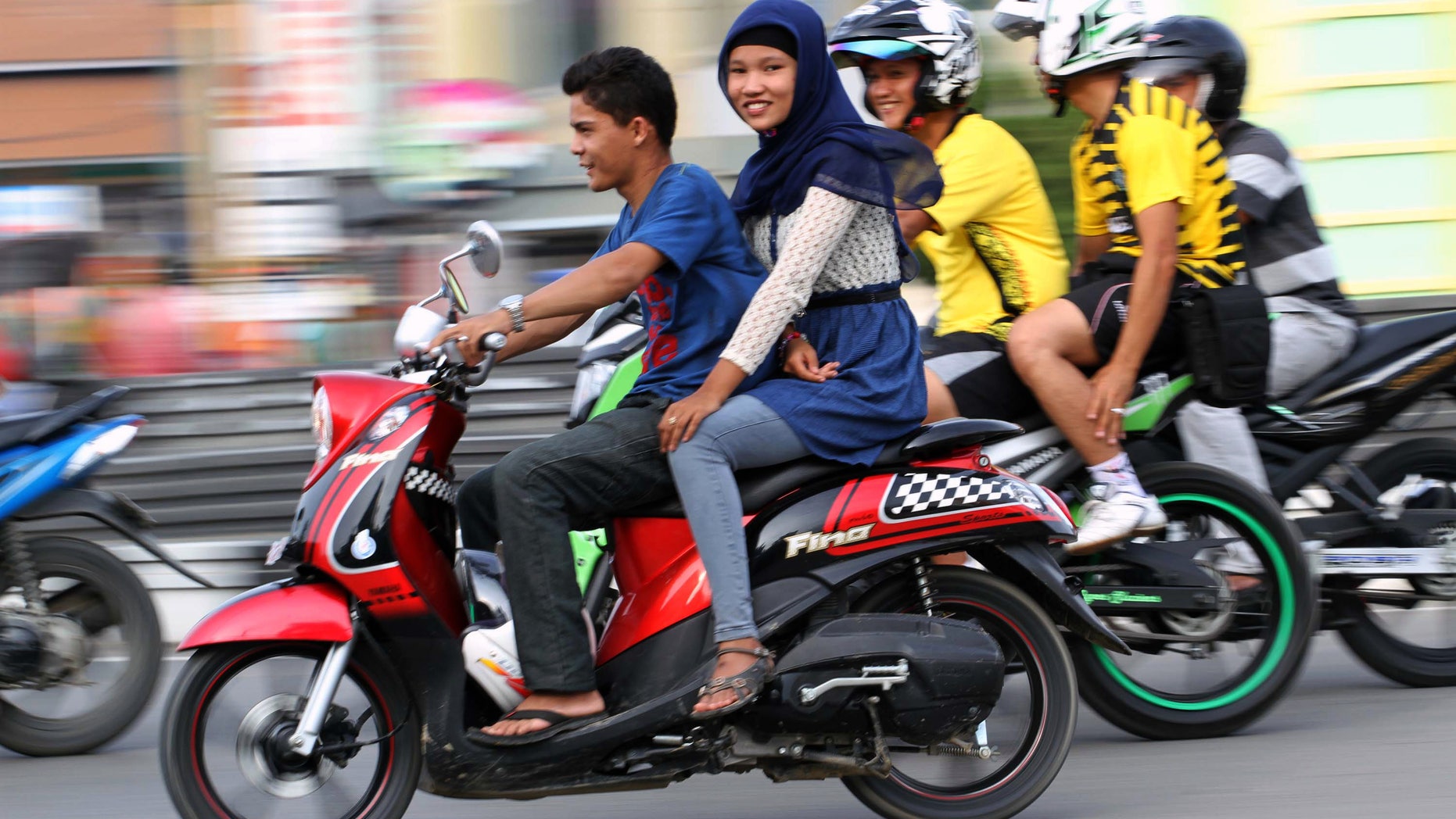 Jan. 7, 2013 - An Acehnese woman straddles on a motorbike on a road in Lhokseumawe, Aceh province, Indonesia.