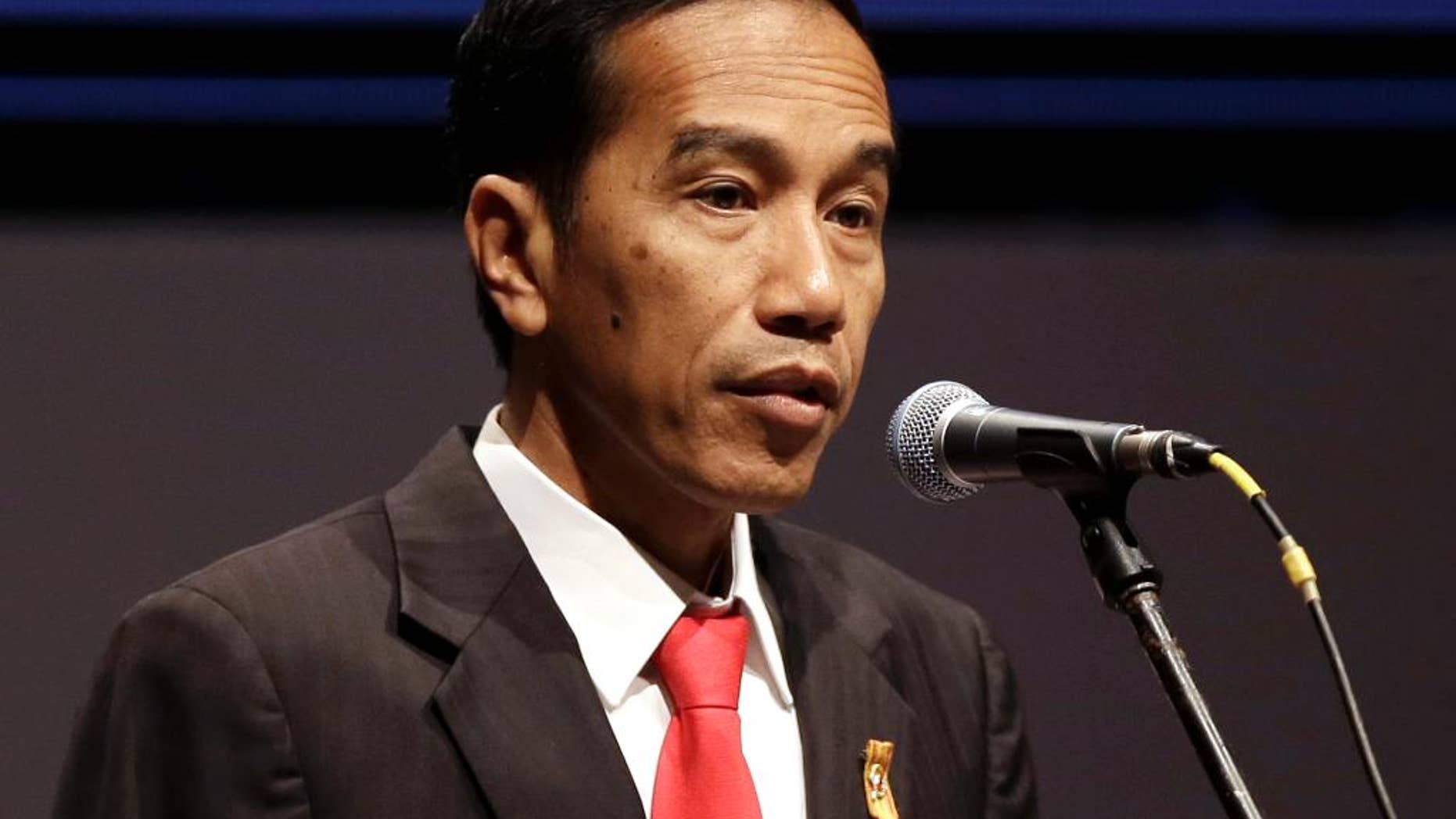 FILE - In this April 21, 2015 file photo, Indonesian President Joko Widodo delivers his remarks during Asian African Business Summit on the sideline of Asian African Conference in Jakarta, Indonesia. Indonesia's president has announced the lifting of a travel ban for foreign journalists to the country's easternmost Papua province and freed five Papuan political prisoners following their appeal for clemency. Widodo announced the lifting of the ban Sunday, May 10, 2015 during his three-day visit to the province. (AP Photo/Dita Alangkara, File)