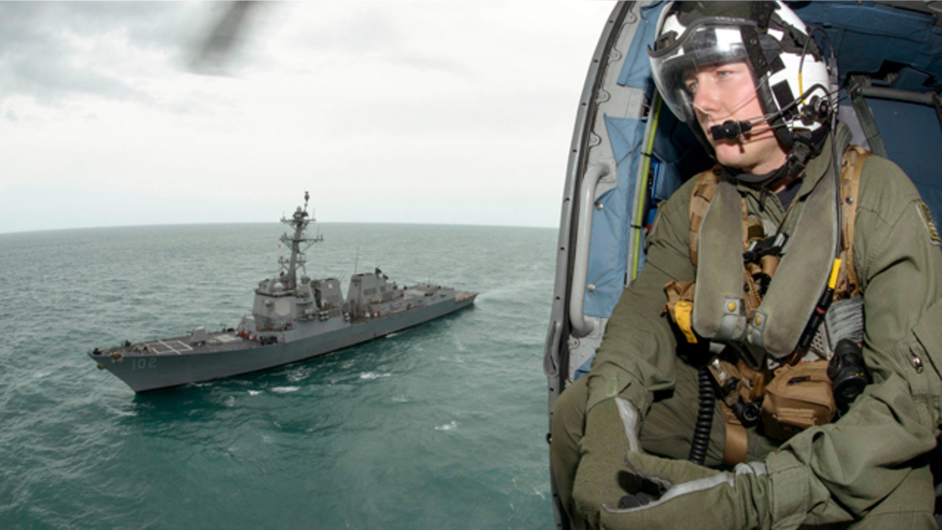 Jan. 6, 2015: Naval aircrewman 2nd Class Cody Witherspoon helps in the search for missing AirAsia Flight 8501 in the Java Sea, as his helicopter returns to the USS Sampson. (AP Photo/U.S. Navy, Petty Officer 1st Class Brett Cote)