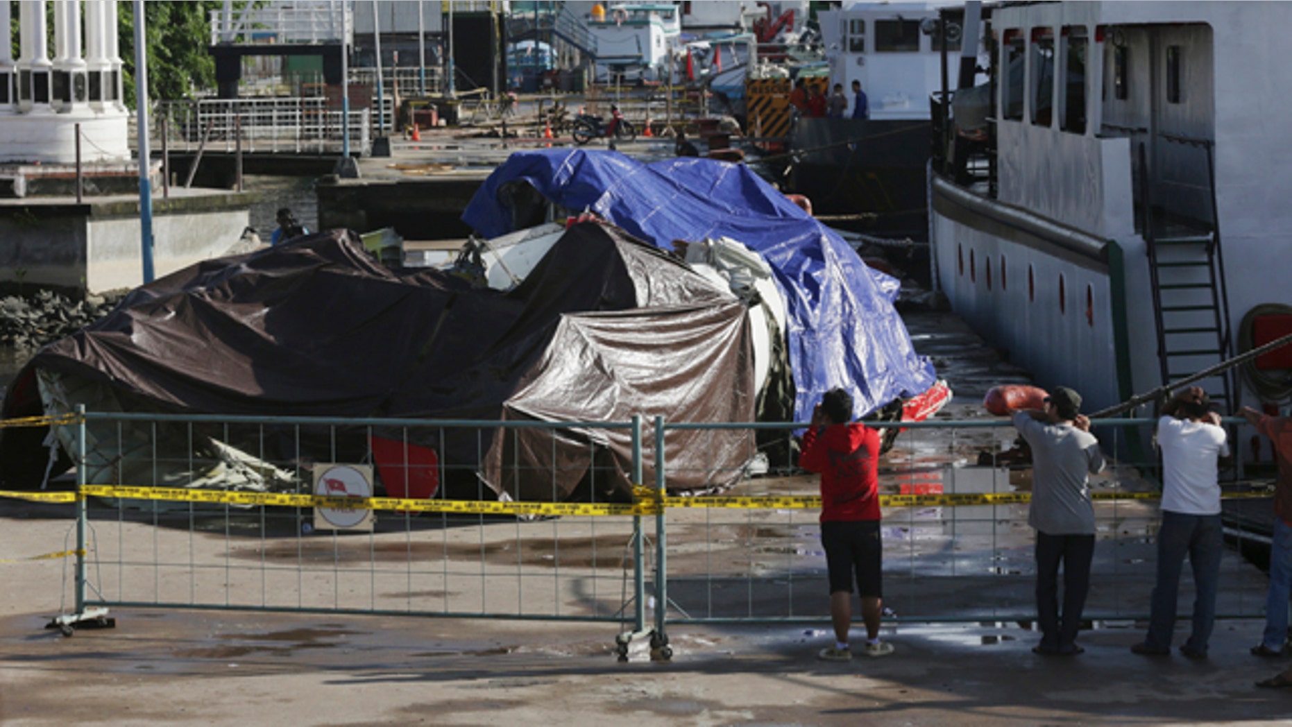 Jan. 12, 2015: Indonesian people look at the wreckage of AirAsia Flight 8501 that crashed in the Java Sea at Kumai port in Pangkalan Bun. (AP Photo/Achmad Ibrahim)