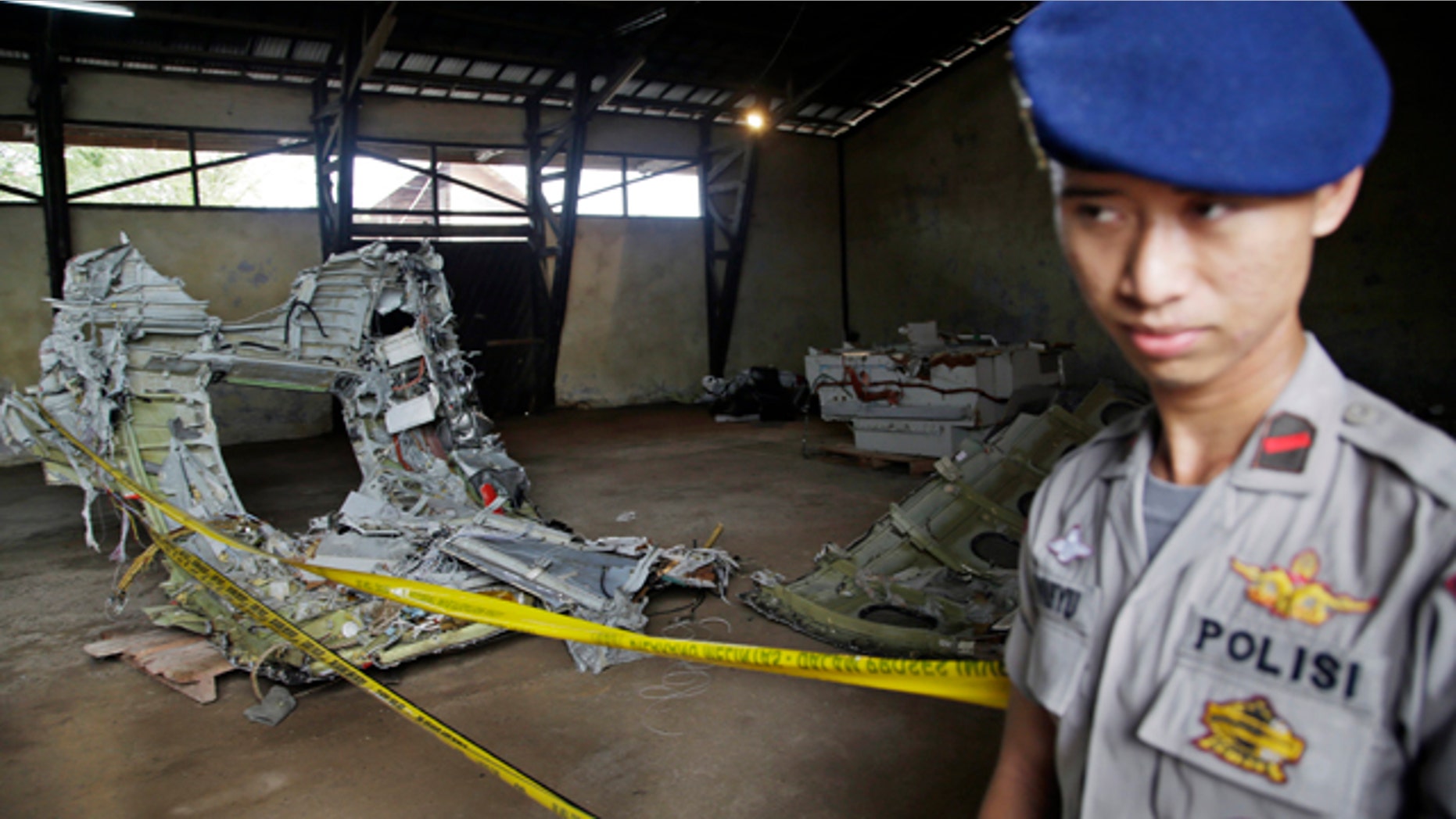 Jan. 19, 2015: An Indonesian police officer stands guard near the wreckage of AirAsia Flight 8501 at a warehouse at Kumai port in Pangkalan Bun. The plane disappeared Dec. 28, 2014 en route from Surabaya, Indonesia, to Singapore. (AP Photo/Achmad Ibrahim)