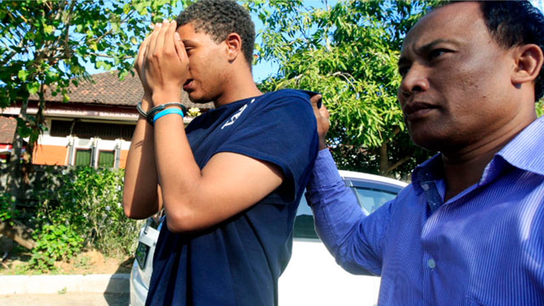 FILE - In this Aug. 13, 2014 file photo, an Indonesian police officer escorts Tommy Schaefer, left, as he is brought to the police station for questioning in relation to the death of his girlfriend's mother, in Bali, Indonesia. The American man has confessed that he killed his girlfriend's mother in a luxury hotel, and the girlfriend has acknowledged helping him stuff the body into a suitcase, Indonesian police said Friday, Sept. 19, 2014. (AP Photo/Firdia Lisnawati, File)