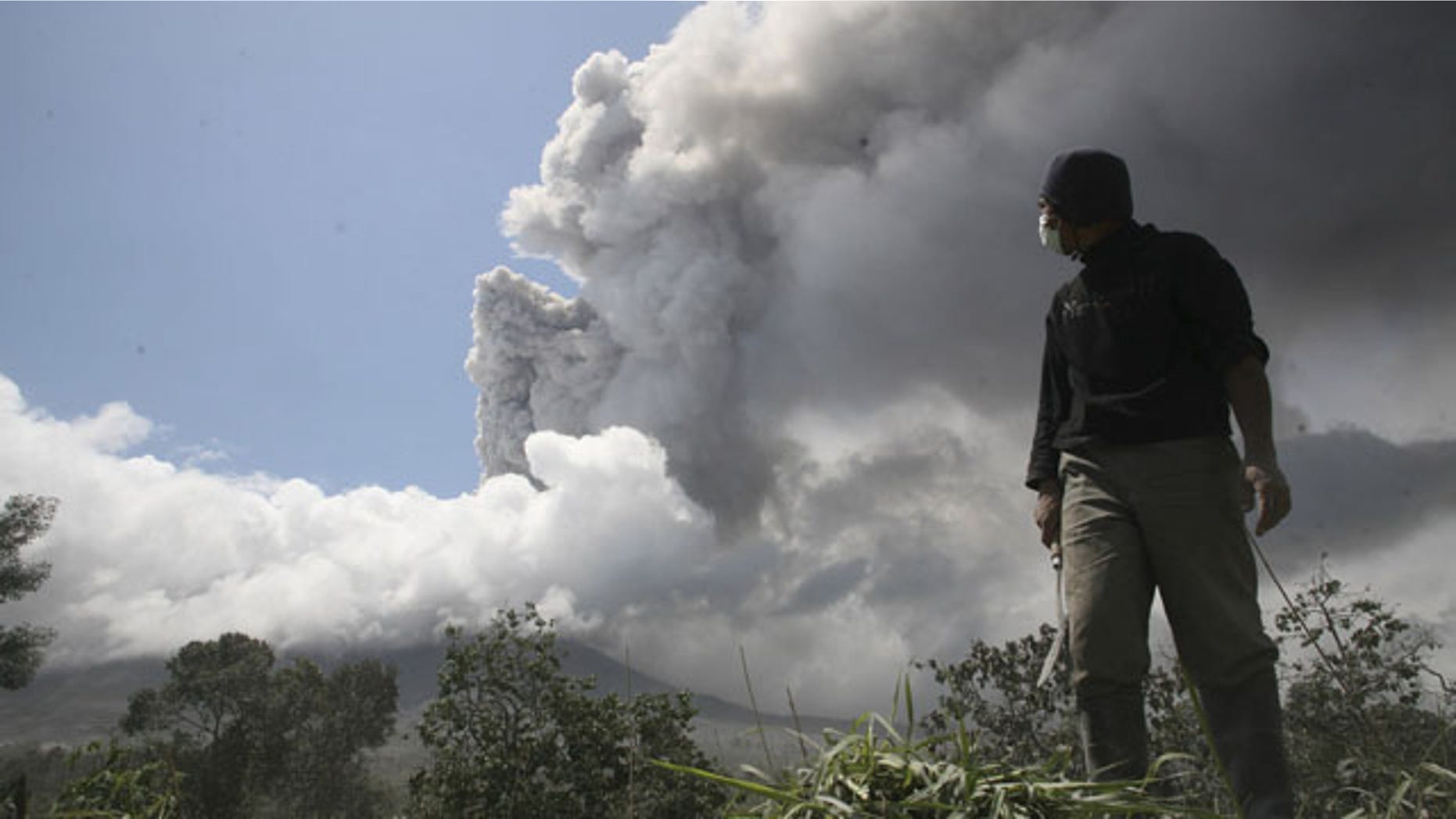 Nov. 10: A man stands on his farm as he looks at volcanic ash rising from Mount Merapi in Magelang, Indonesia. Volcanic debris has been spewing for more than two weeks, killing at least 191 people and impeding travel.