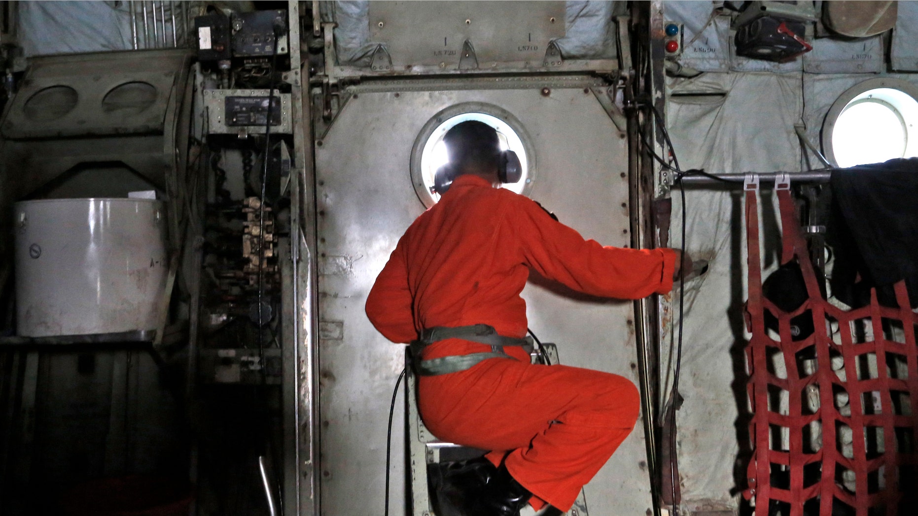 Dec. 29, 2014: A crew of an Indonesian Air Force C-130 airplane of the 31st Air Squadron, looks out of the window during a search operation for the missing AirAsia flight 8501 jetliner over the waters of Karimata Strait in Indonesia.