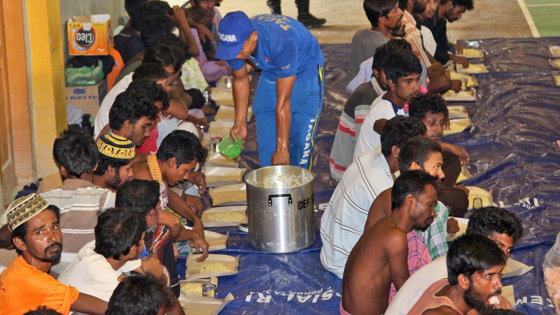 May 11, 2015 - Ethnic Rohingya migrants receive food from a social worker at a temporary shelter in Lhok Sukon, Aceh province, Indonesia. Boats carrying nearly 600 Bangladeshis and long-persecuted Rohingya Muslims from Myanmar washed ashore in western Indonesia, some after captains and smugglers abandoned the ships, survivors said.