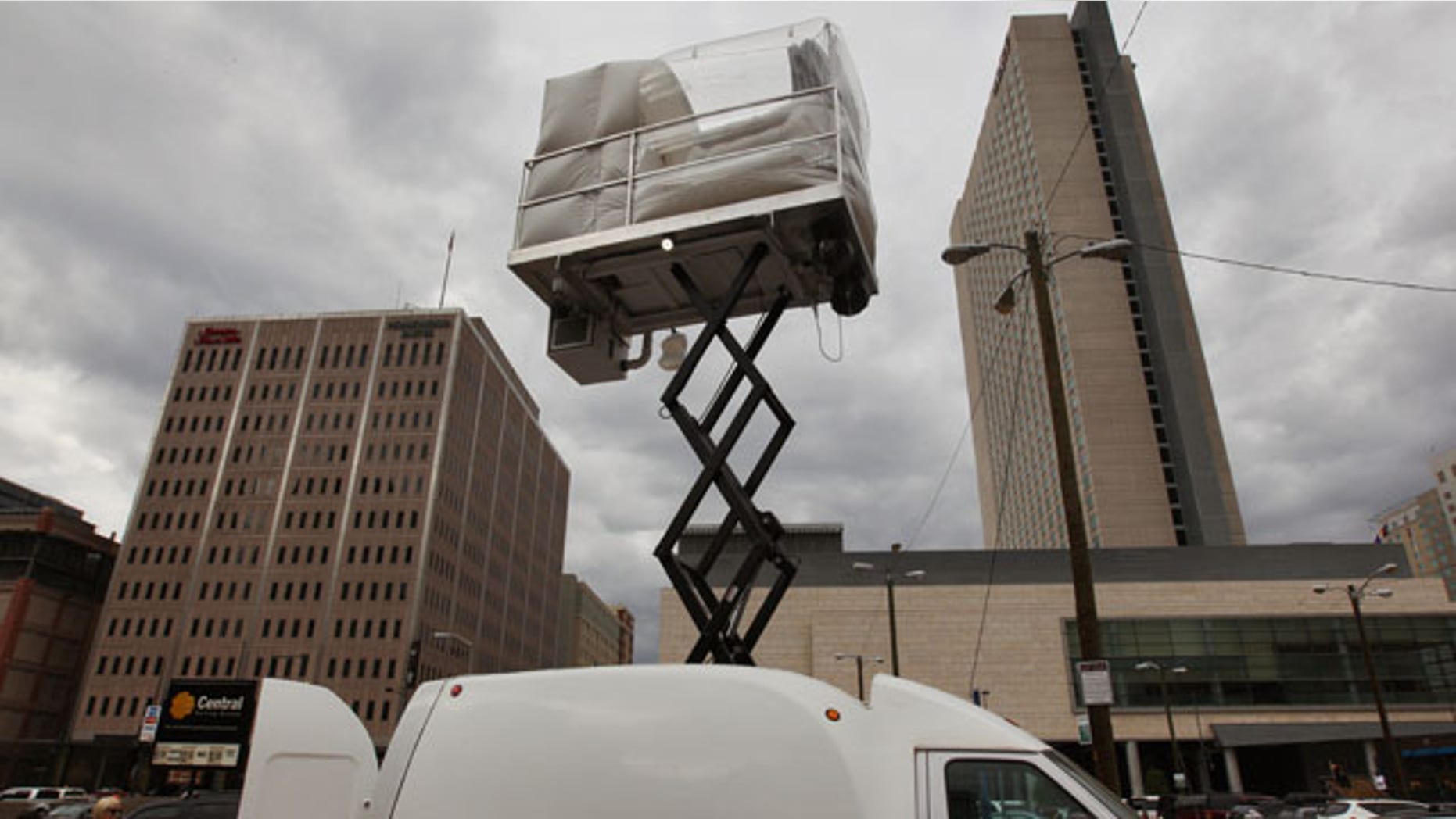 July 25, 2013: A hotel room made of aluminum and inflated vinyl is held aloft by a van-mounted scissor lift, on promotional display in a parking lot in downtown Denver. Architectural artist Alex Schweder created the 5 by 7 foot room atop a van for the Biennial of the Americas in Denver. For $50,000, a guest would get one weekend night in the puffy space, plus lots of extras including a diamond pendant and earring set, two iPod Nanos and a dance party for 100 people in a ballroom of The Curtis Hotel. (AP Photo)