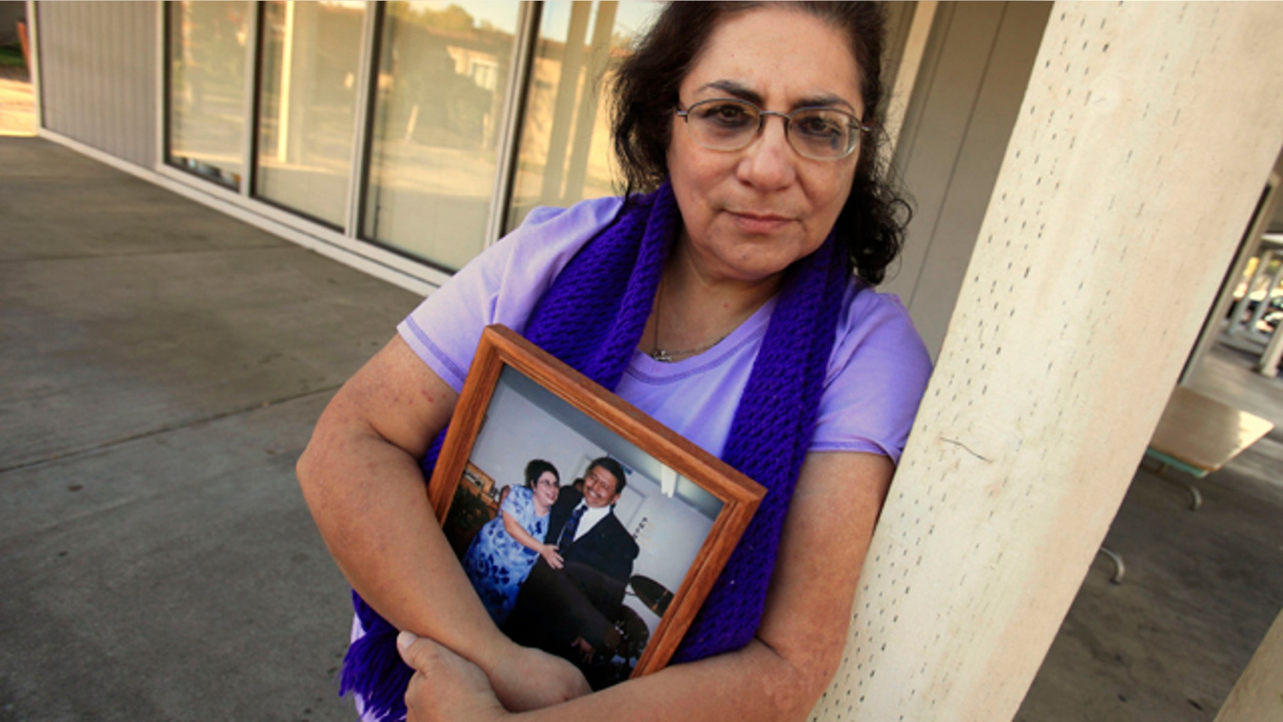 Nov. 4, 2011: Karen Carrisosa is seen with a photo of her and her husband Larry, at the site where he was killed in Sacramento, Calif. Carrisosa is a victim of a disturbing trend: Inmates who use smuggled mobile devices or work through third parties to access social networking sites -- giving them the ability to harass their victims and victim's families.