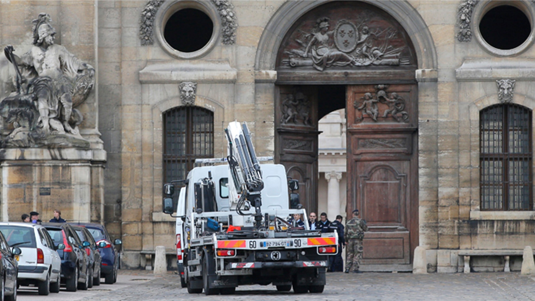 Dec.16, 2015: Police officers and soldiers stand by a heavy wooden door after a car rammed the entrance at France's Invalides monument in Paris. The driver was arrested.