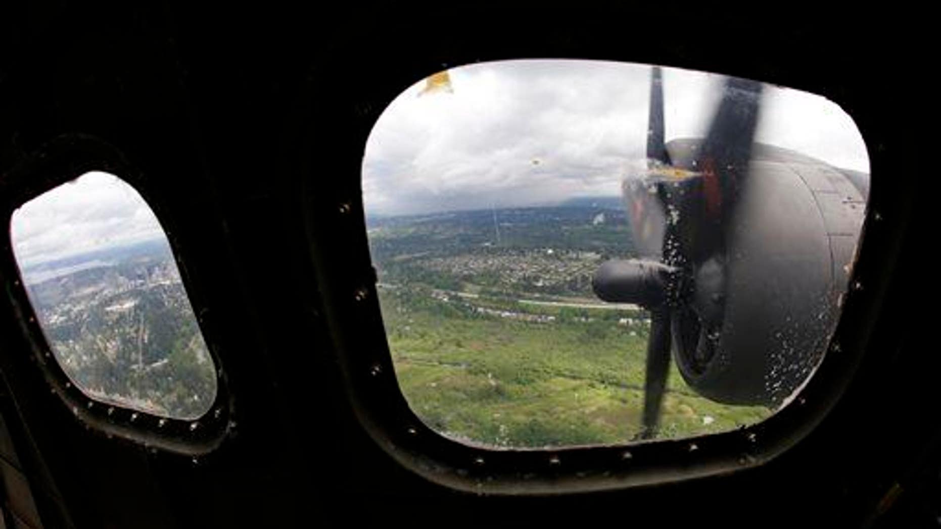 Two of the four engines of a Boeing B-17 "Flying Fortress" bomber are shown through a window May 5, 2014, as it flies near Seattle.