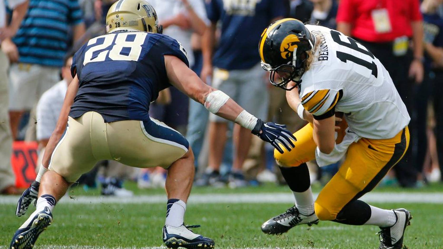 Iowa quarterback C.J. Beathard (16) slides before being tackled by Pitt linebacker Anthony Gonzalez (28) after a short gain during the fourth quarter of an NCAA college football game in Pittsburgh, Saturday, Sept. 20, 2014. Iowa won 24-20. (AP Photo/Gene Puskar)