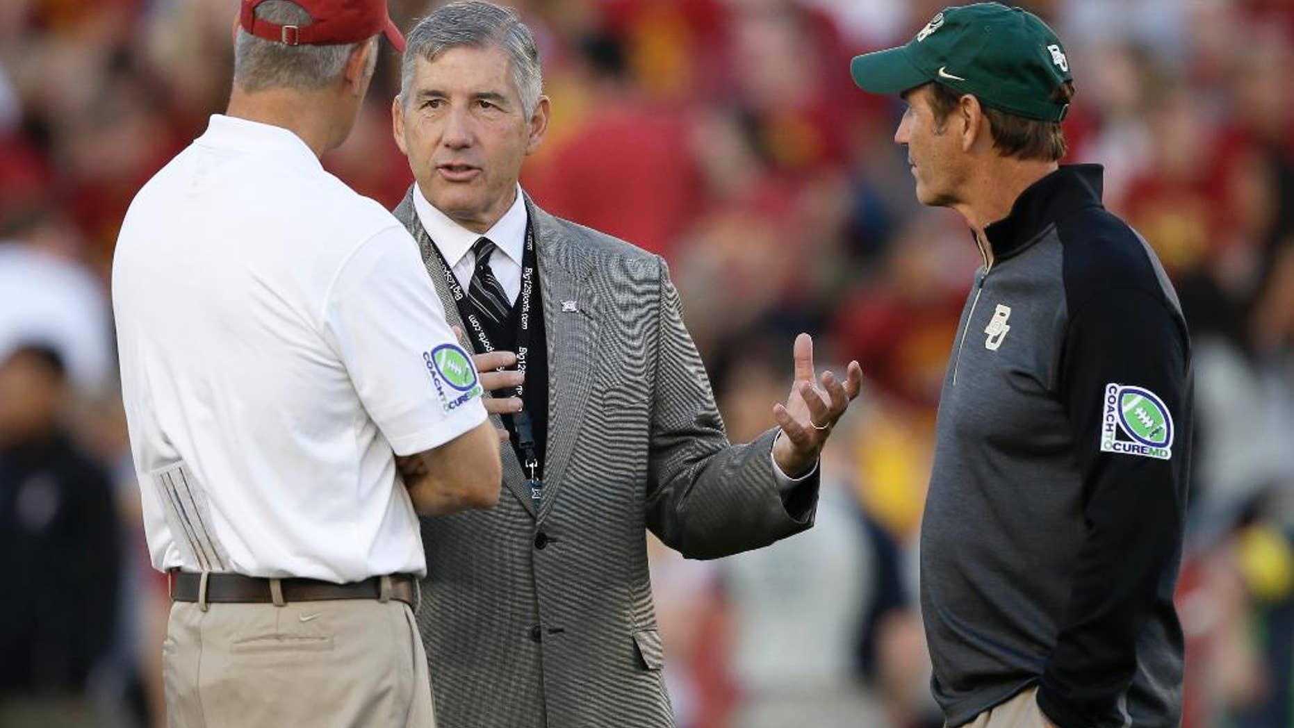 FILE- In this Sept. 27, 2014, file photo, Big 12 Conference Commissioner Bob Bowlsby, center, talks with Iowa State coach Paul Rhoads, left, and Baylor coach Art Briles before an NCAA college football game in Ames, Iowa. The Big 12 has publicly reprimanded and fined Iowa State athletic director Jamie Pollard $25,000 for his rant against league officiating. (AP Photo/Charlie Neibergall)