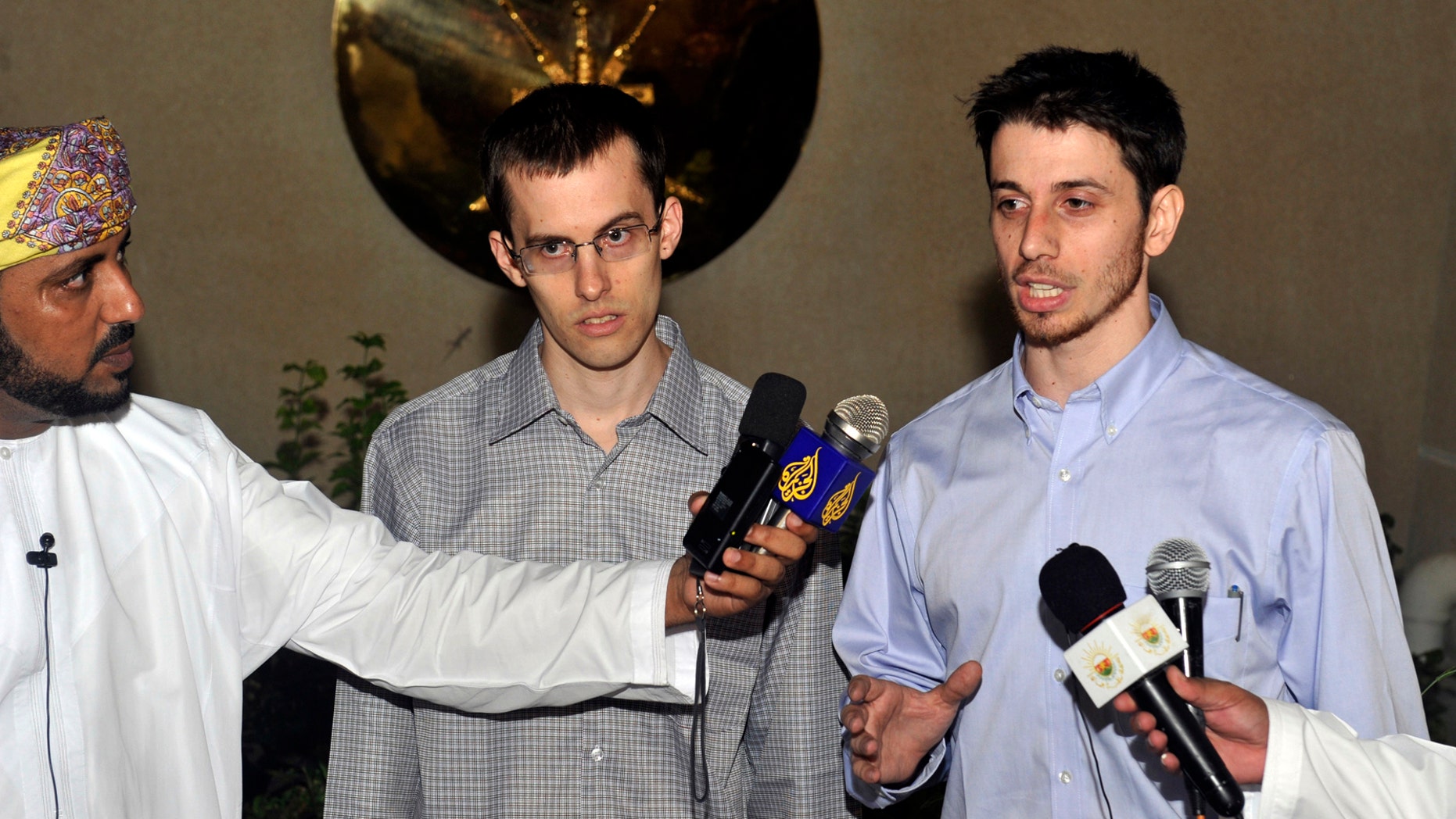 Freed American Shane Bauer, center, and Josh Fattal, right, talk to the media upon their arrival from Iran, in Muscat, Oman Wednesday, Sept. 21, 2011.