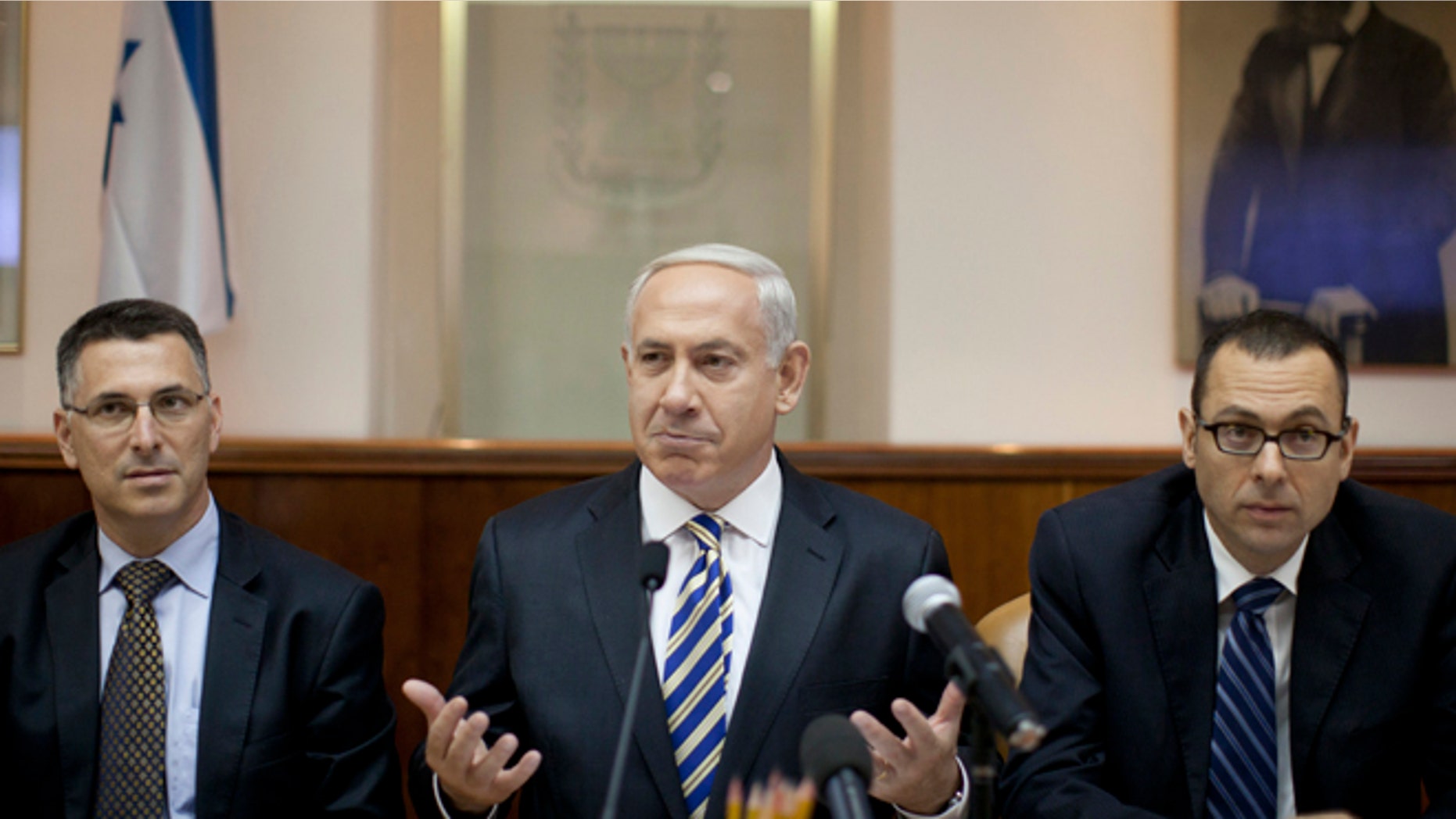 Aug. 26, 2012: Israeli Prime Minister Benjamin Netanyahu, center, heads the weekly cabinet meeting attended by the Israeli Education Minister Gideon Saar, left, and the cabinet secretary, Zvi Houser, right, in the prime minister's office in Jerusalem, Israel.