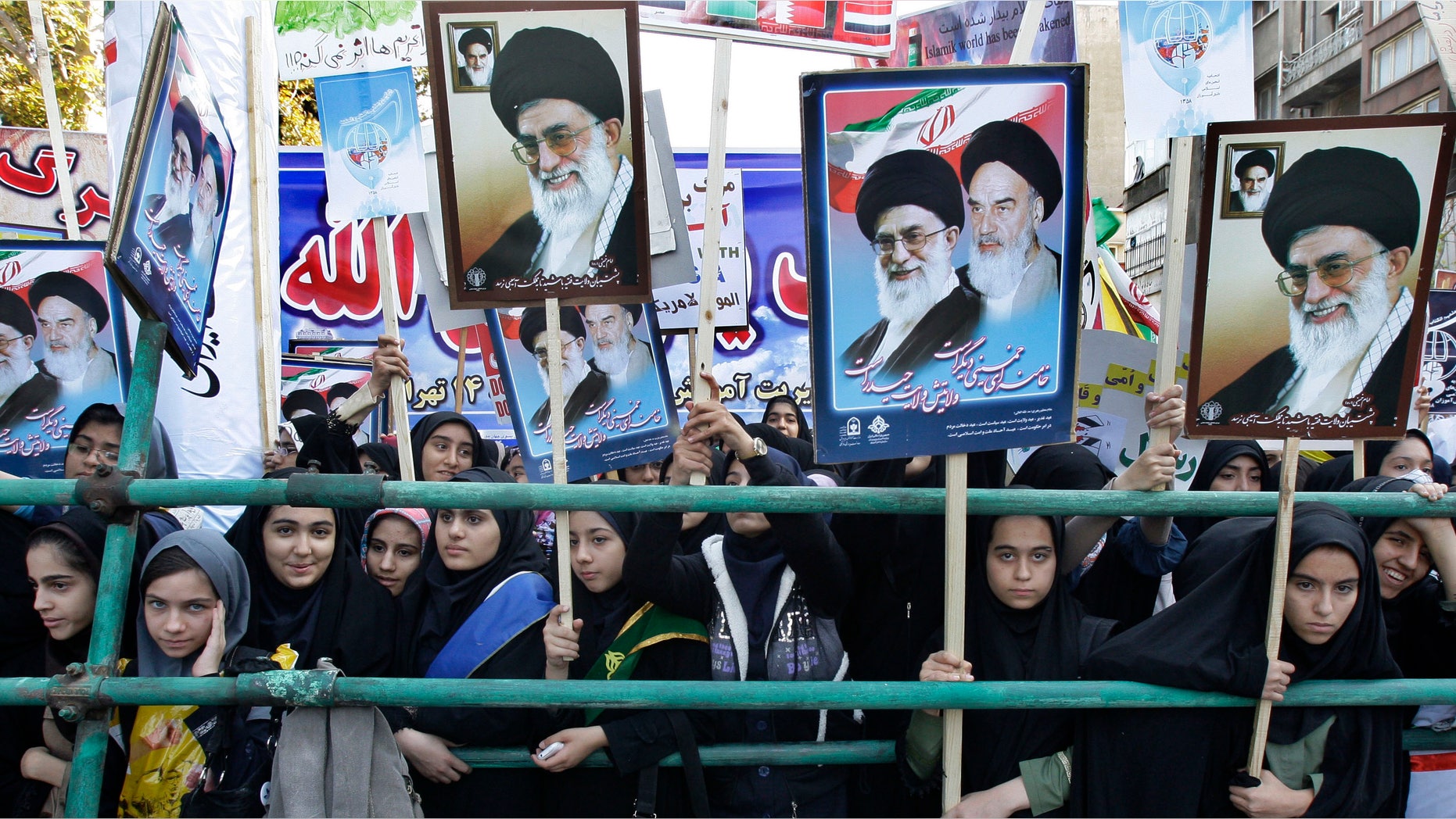 Nov. 2, 2012: Holding posters of the late revolutionary founder Ayatollah Khomeini, and Supreme Leader Ayatollah Ali Khamenei, Iranian girls attend an annual state-backed rally in front of the former US Embassy in Tehran, Iran. The rally marks the Nov. 4, 1979, storming of the building by militant students who held 52 Americans hostage for 444 days to protest U.S. failure to hand over the toppled shah Mohammad Reza Pahlavi to Iran for trial.