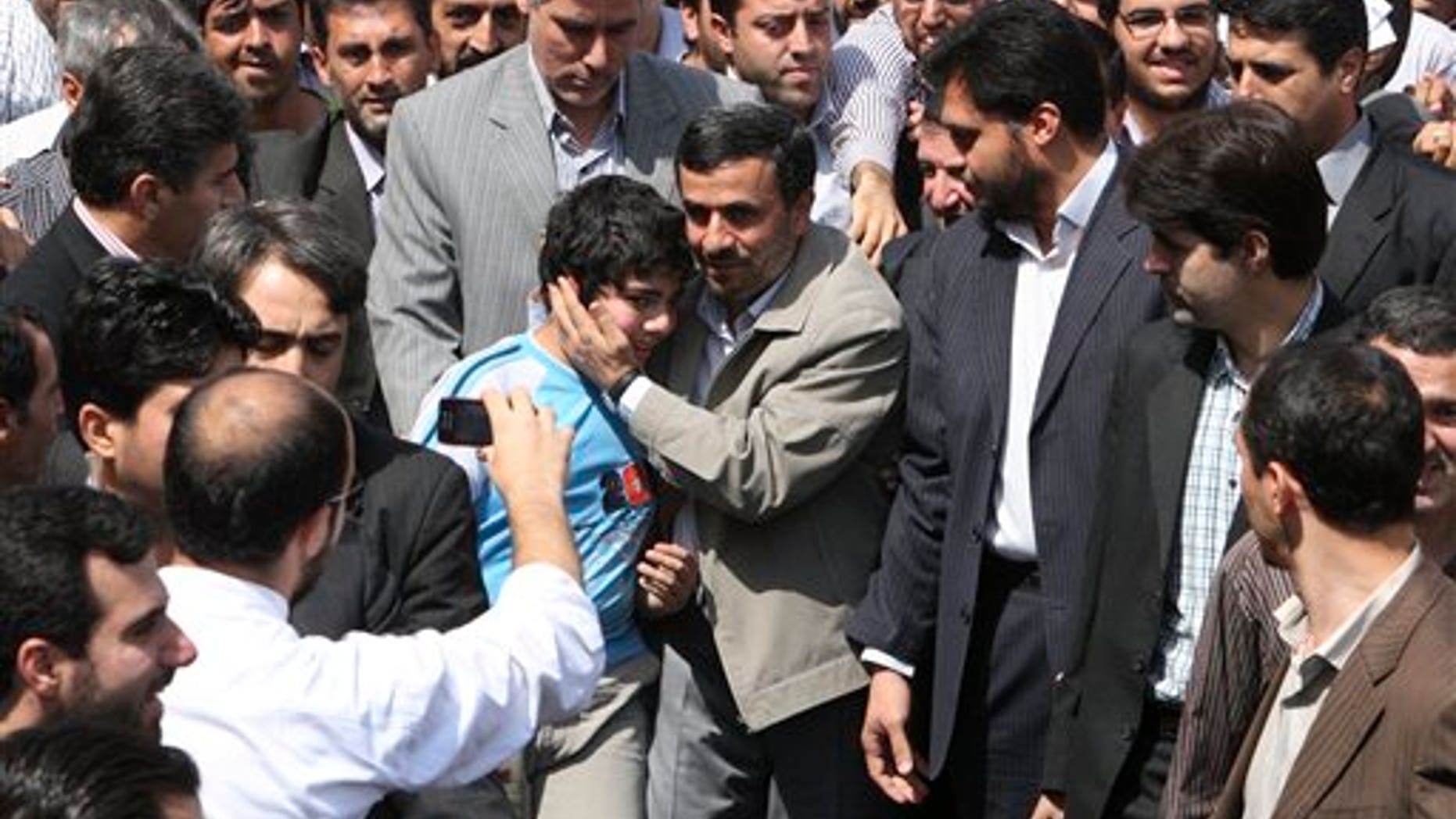 August 26: Escorted by his bodyguards, Iranian President Mahmoud Ahmadinejad, center, greets a boy, as he attends an annual nation-wide pro-Palestinian rally known as Quds Day, in Tehran, Iran.