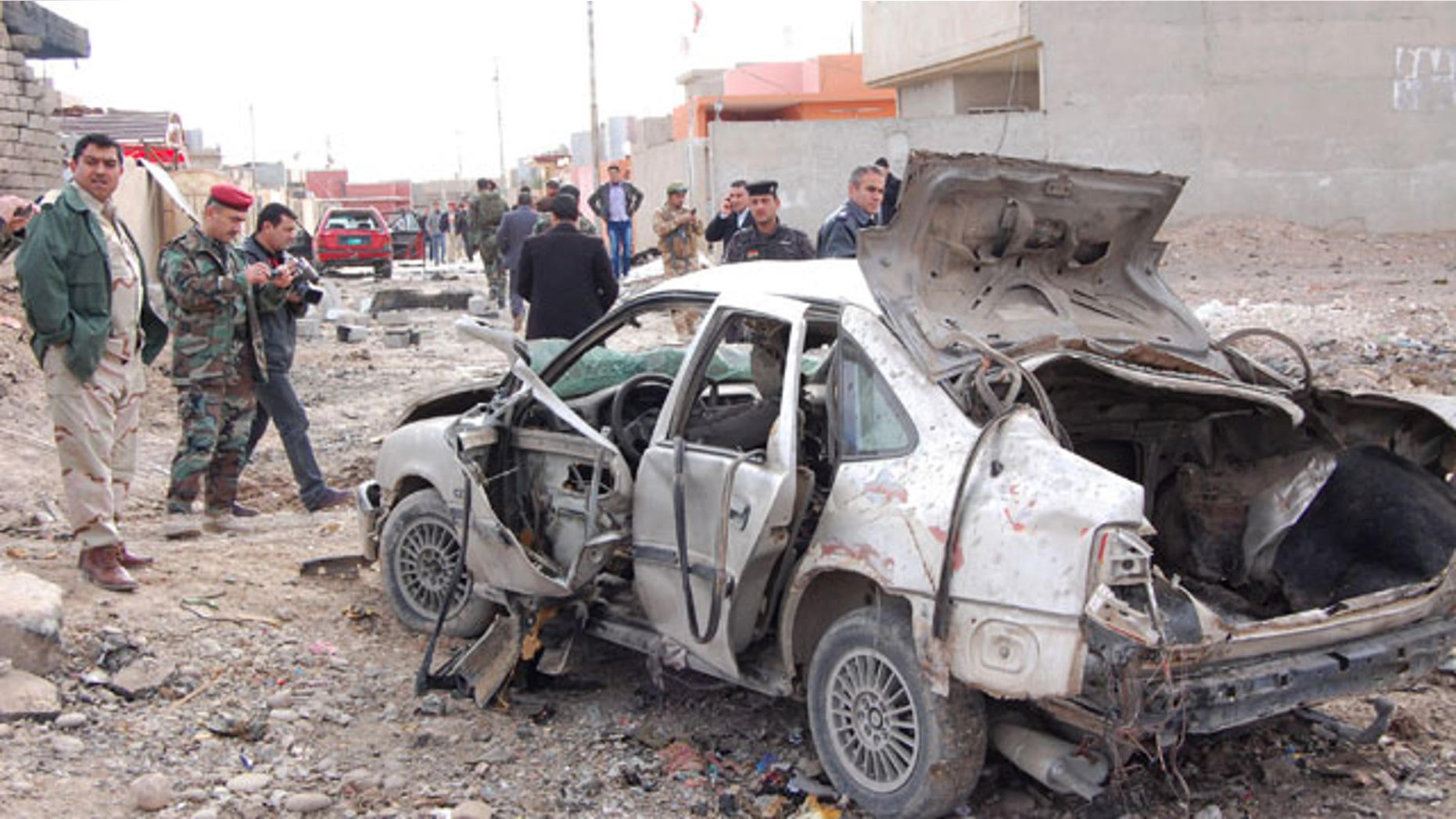 January, 16, 2012: Iraqi security forces inspect the scene of a car bomb attack outside the northern city of Mosul, 225 miles northwest of Baghdad, Iraq.