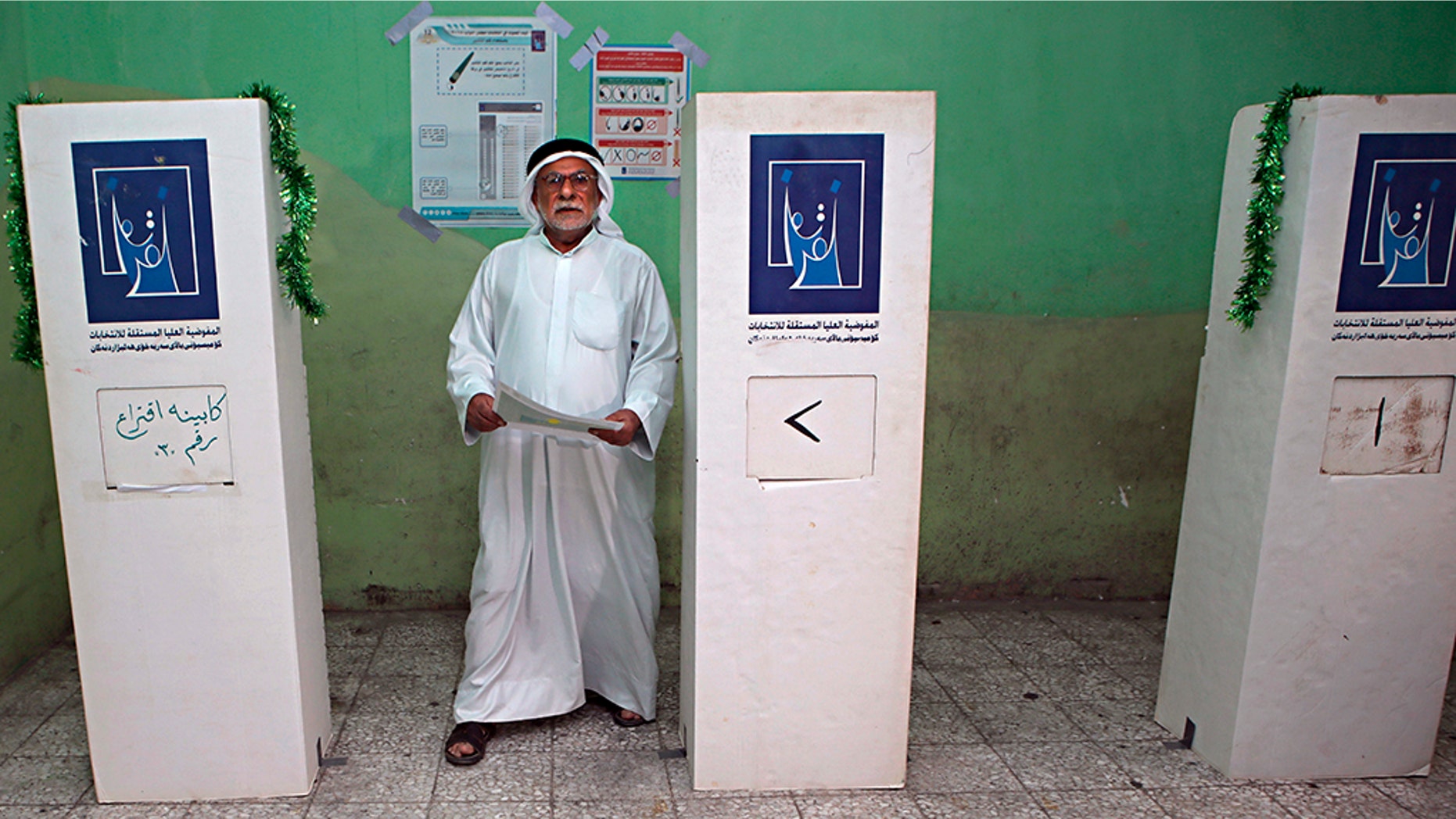 An Iraqi man prepares to casts his vote in the country's parliamentary elections in Basra, 340 miles (550 kilometers) southeast of Baghdad, Iraq, Saturday, May 12, 2018. Polls opened across Iraq on Saturday in the first national election since the declaration of victory over the Islamic State group. (AP Photo/Nabil al-Jurani)