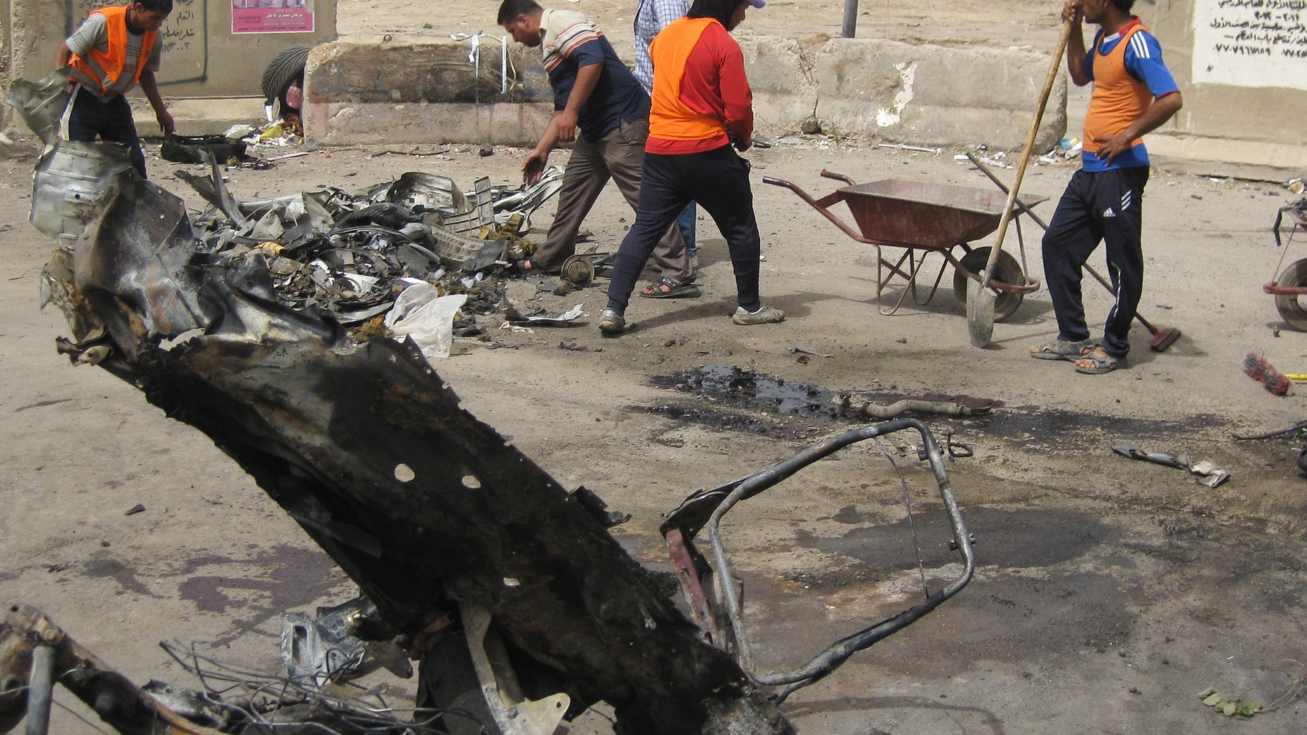 April 19, 2012: Baghdad municipality workers clean up after a car bomb attack in Palestine Street, Baghdad.
