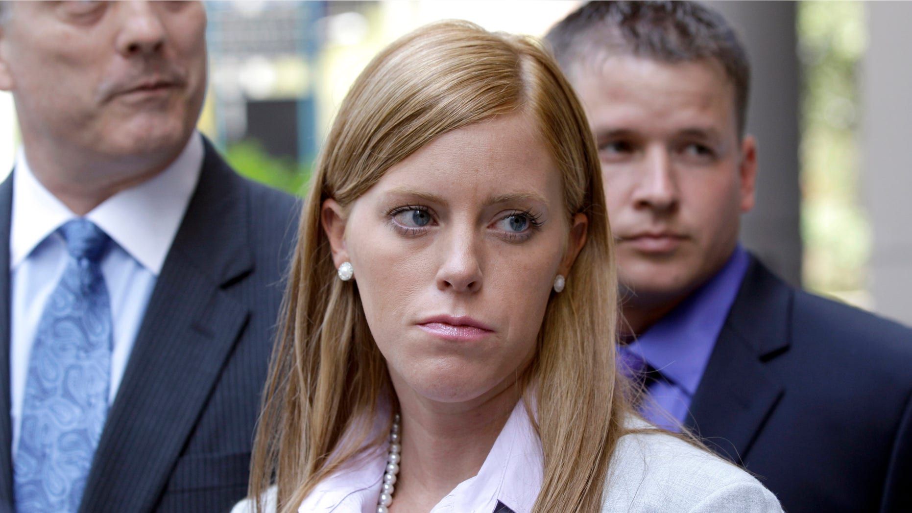 Jamie Leigh Jones, center, listens to a question along with her husband, Kallan Daigle, right, and attorney Todd Kelly, left, outside the federal courthouse Tuesday, June 14, 2011, in Houston. Opening statements began Tuesday in the civil lawsuit filed by Jones, an ex-female contractor who claims she was raped by co-workers in Iraq in 2005 while employed by a former Halliburton Co. subsidiary and then held against her will when she tried to report the assault.